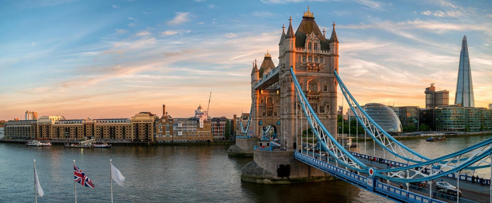 a suspension bridge over the water in front of a city at The Tower Hotel, by Thistle in London