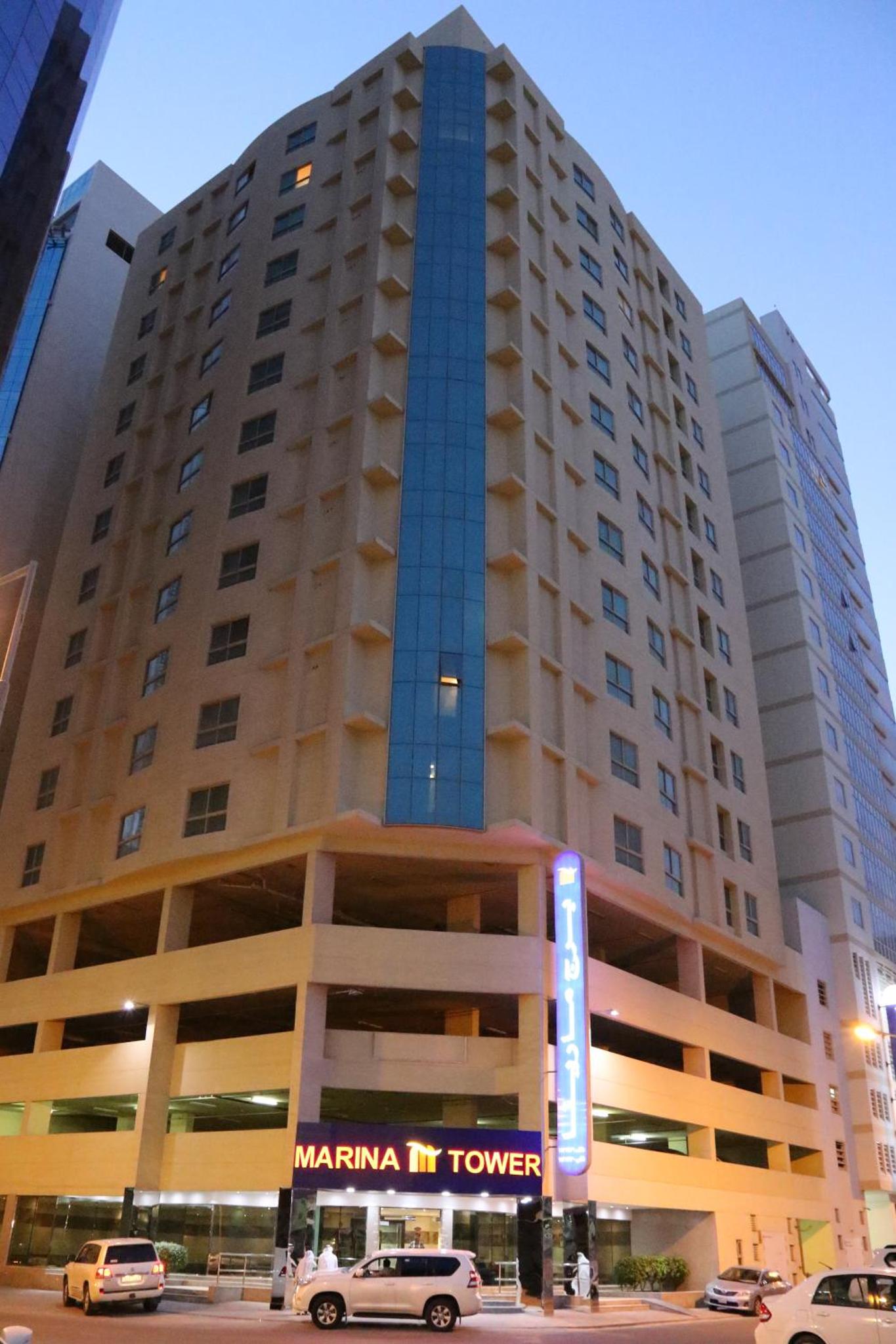 a large building with cars parked in front of it at Marina Tower in Juffair