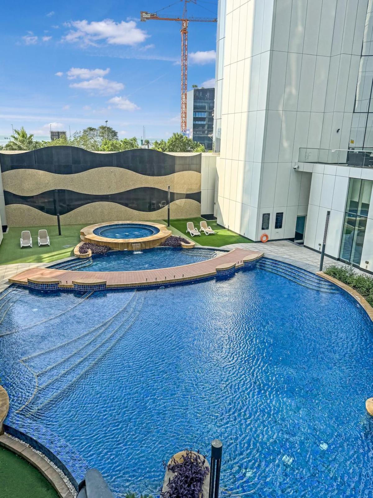 a large swimming pool in front of a building at 2 Bedroom Apartment in Bahrain Bay with a four season view in Manama