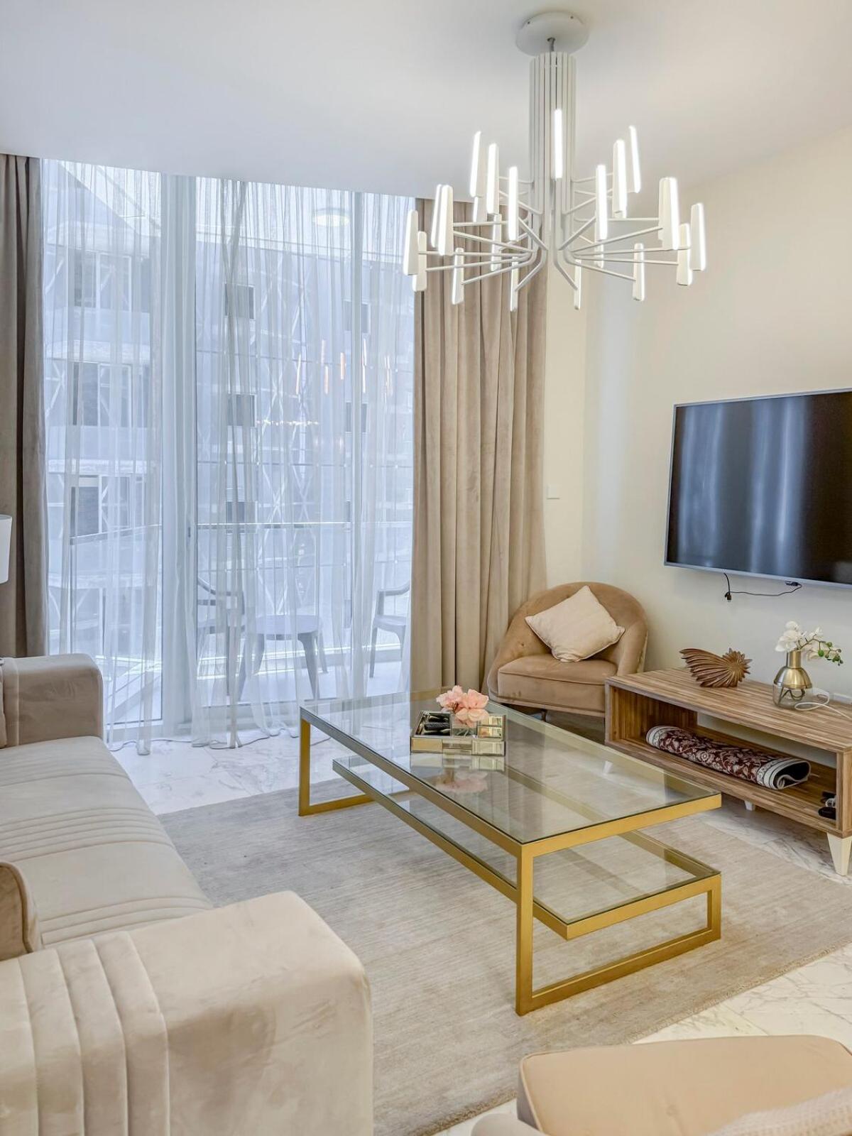 a living room with a couch and a tv at 2 Bedroom Apartment in Bahrain Bay with a four season view in Manama