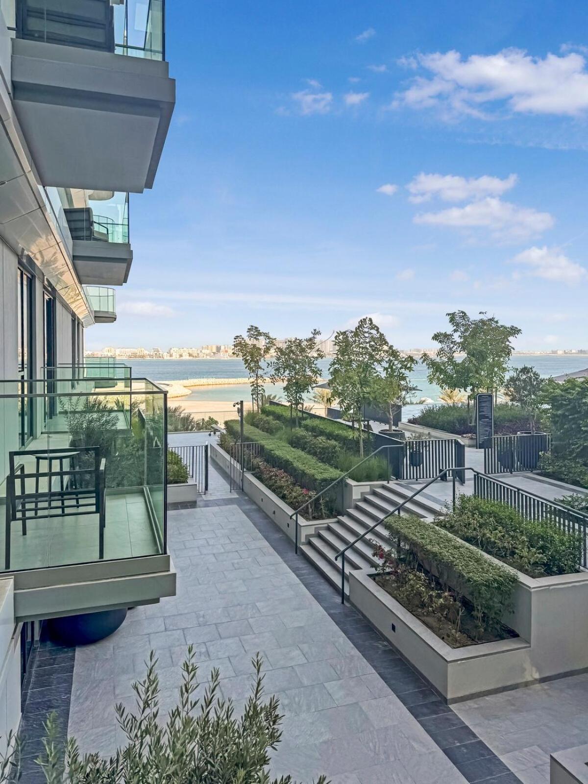 a balcony of a building with a view of a garden at Luxurious Sea and Pool View Studio in Marassi Vista Al Bahrain in Muharraq