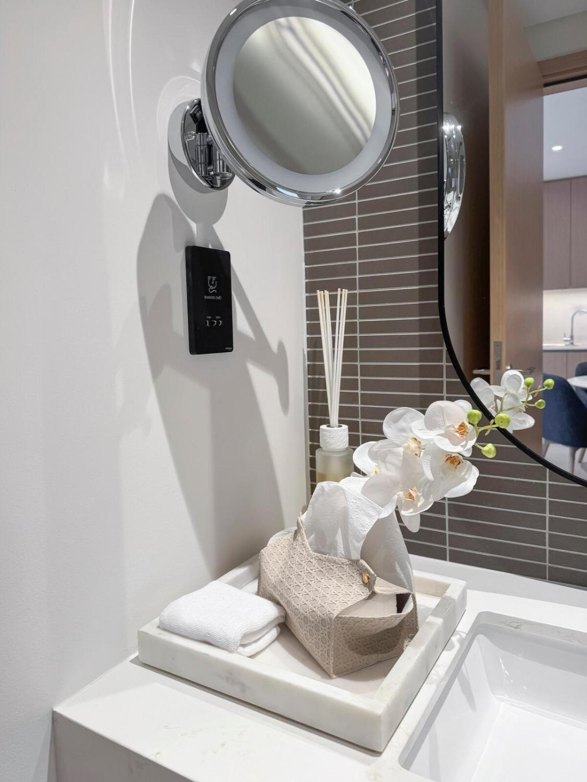 a bathroom with a sink with a mirror and towels at Luxurious Sea and Pool View Studio in Marassi Vista Al Bahrain in Muharraq