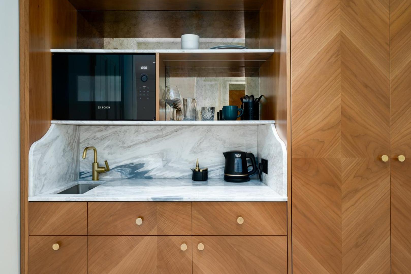 a kitchen with a sink and a microwave at GuestReady - The Fitzroy in London +59 photos