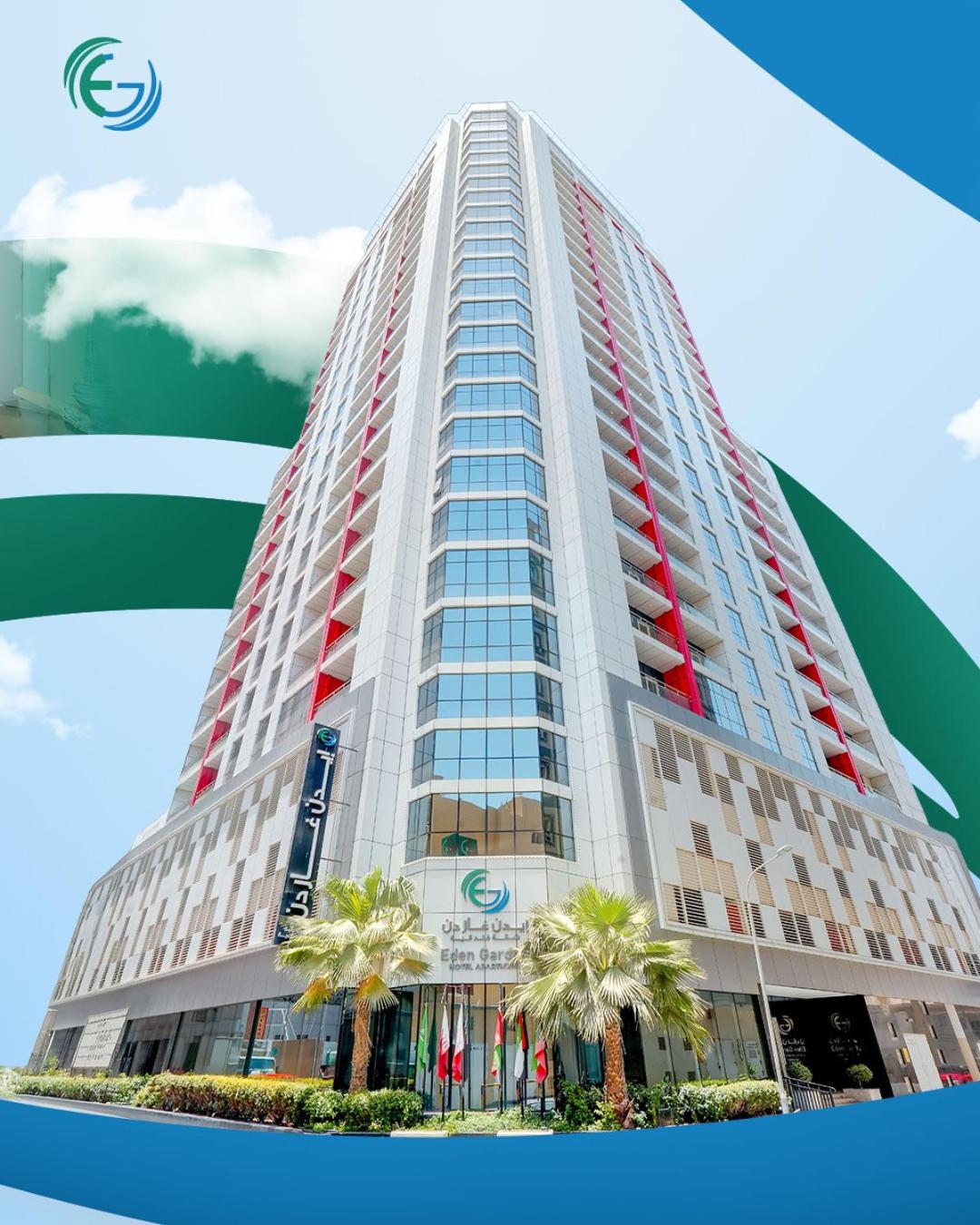 a tall building with palm trees in front of it at Eden Garden Hotel Apartment in Manama