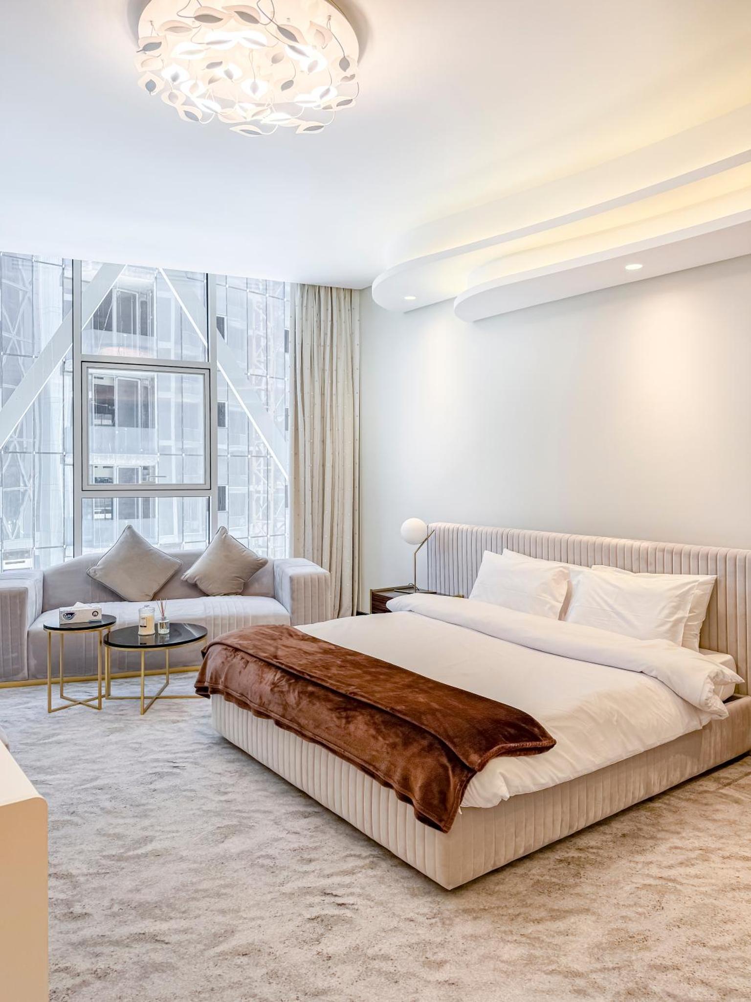 a bedroom with a large bed and a couch at Luxurious 2BR APT in Bahrain Bay in Manama +57 photos