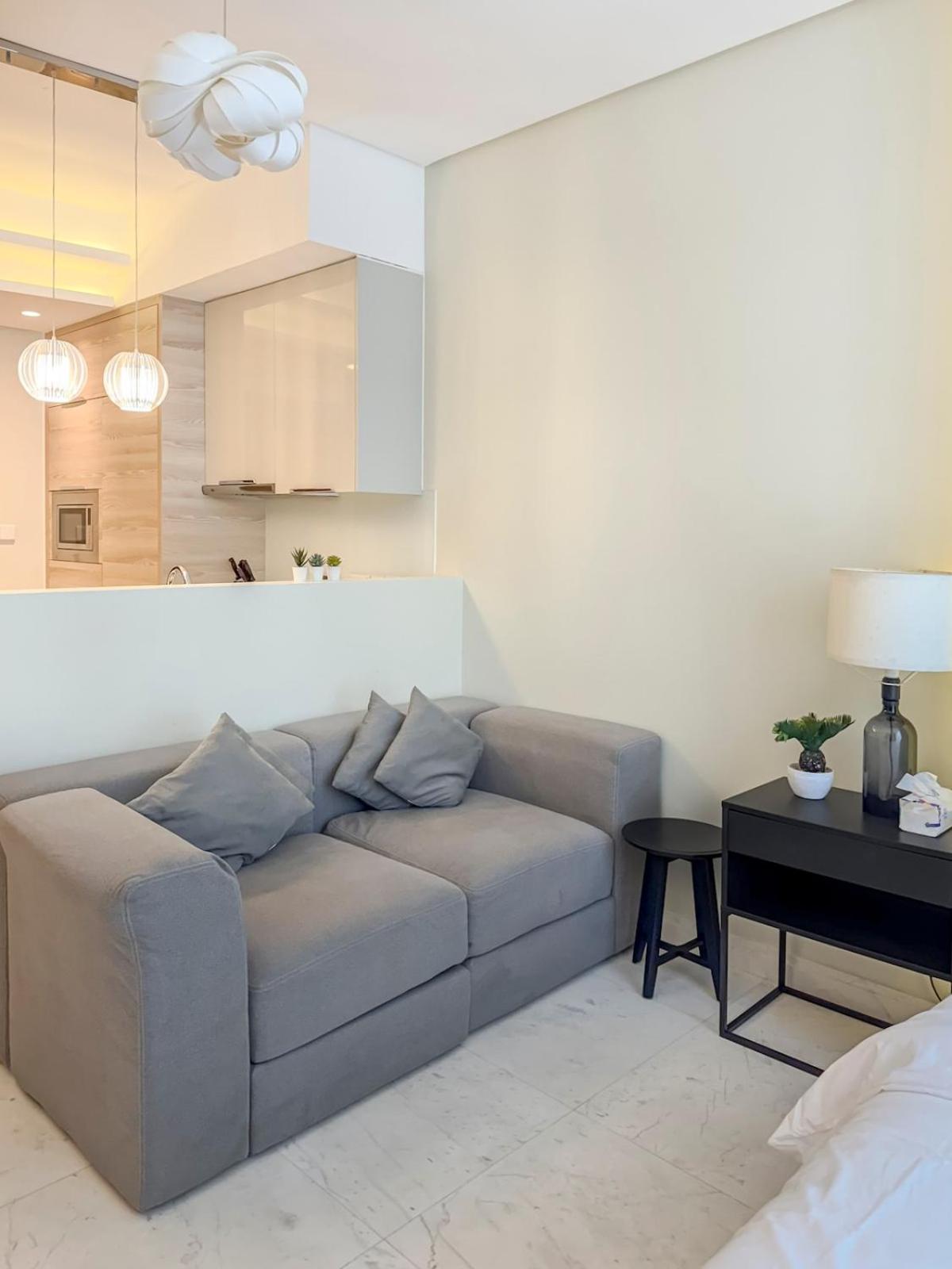 a living room with a couch and a table at Cozy Studio in Bahrain Bay Waterfront in Manama