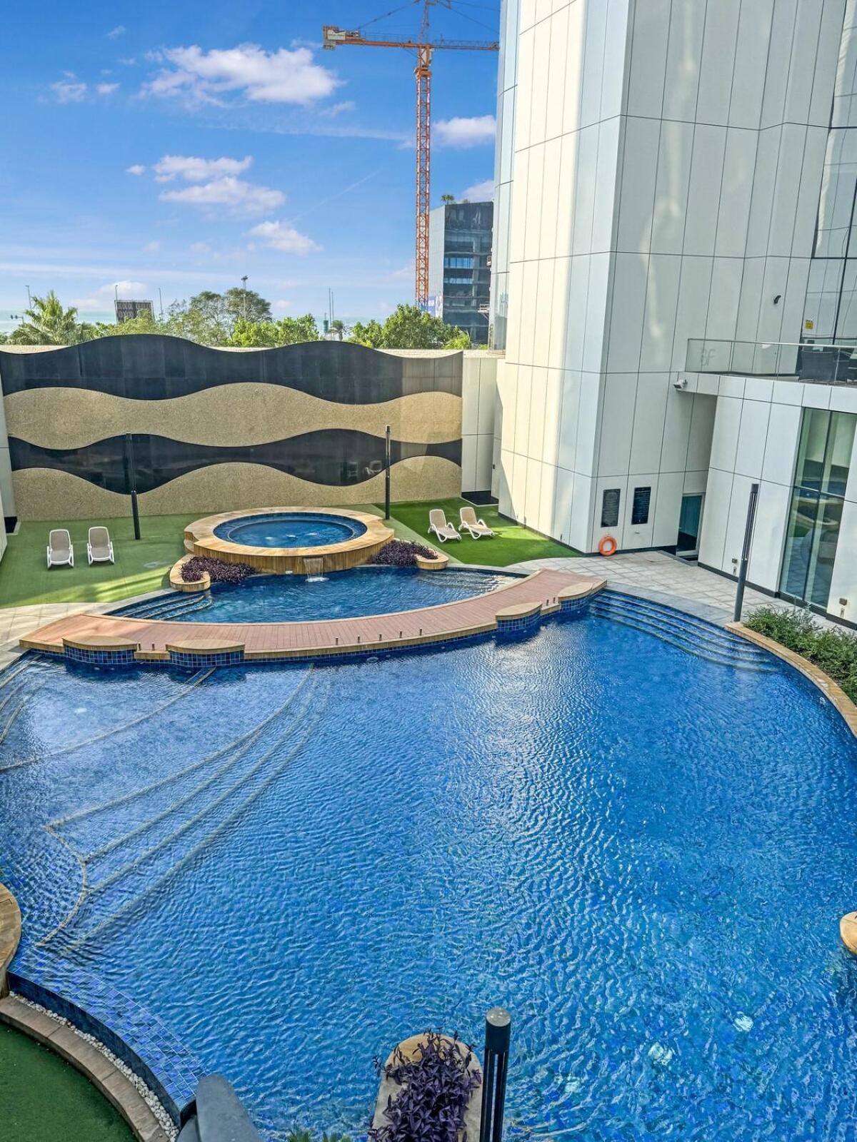 a large swimming pool in front of a building at Cozy Studio in Bahrain Bay Waterfront in Manama