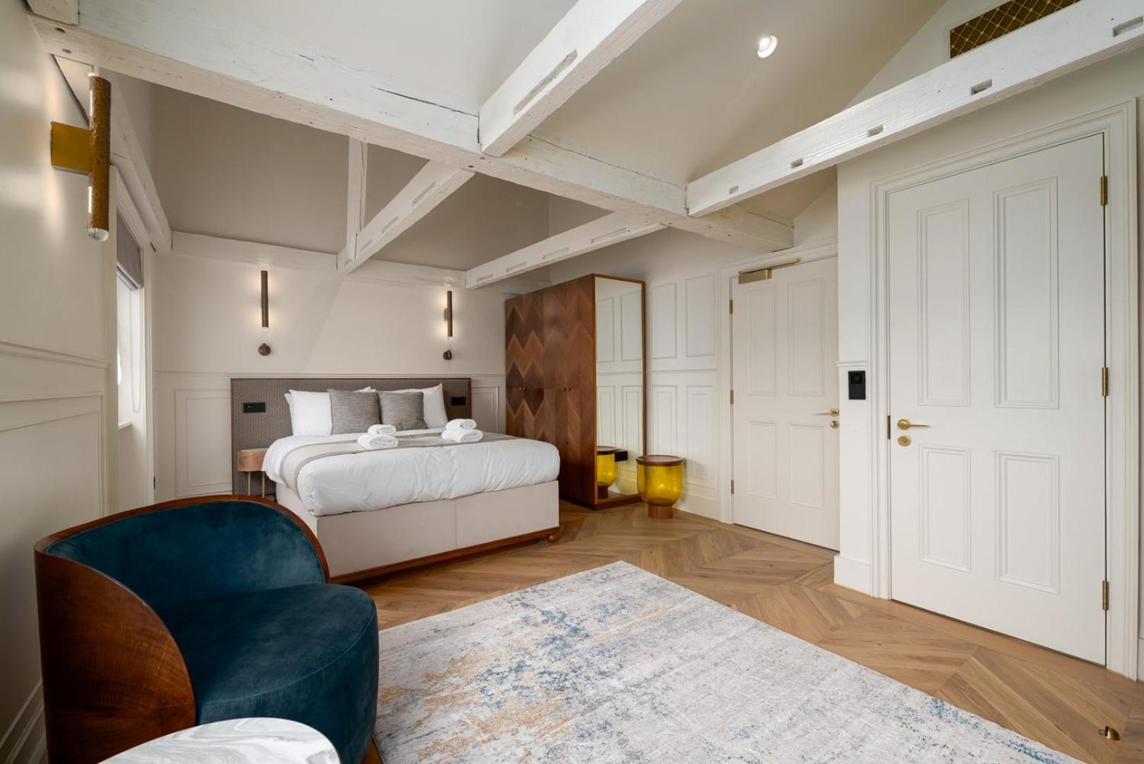 a bedroom with a bed and a blue chair at GuestReady - The Fitzroy in London