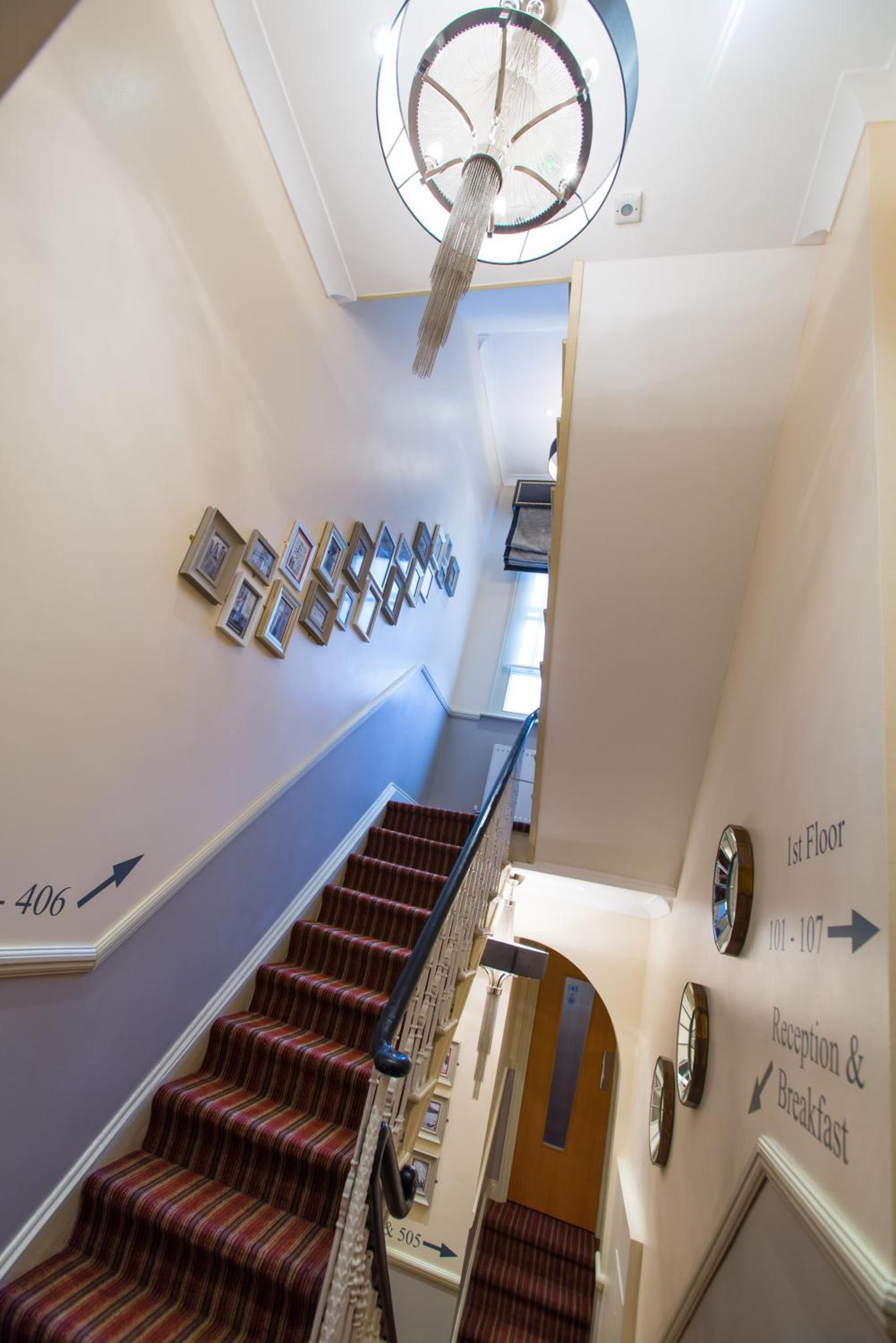 a staircase in a building with a chandelier at Best Western Buckingham Palace Rd in London +151 photos