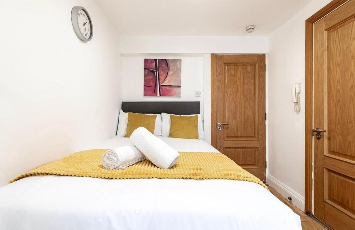 a bedroom with a white bed with two pillows at Hyde Park Budget Studios! in London