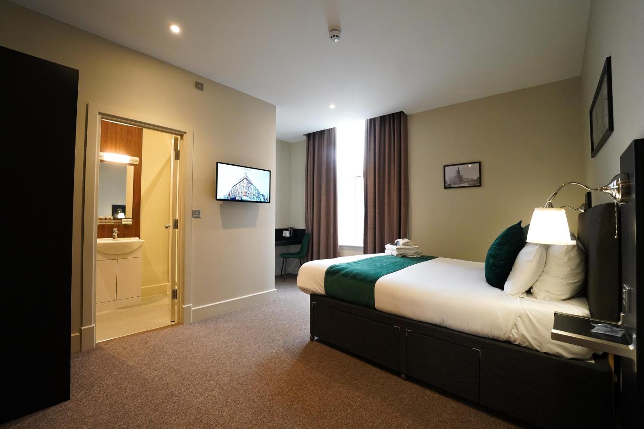 a hotel room with a bed and a television at Keystone House in London