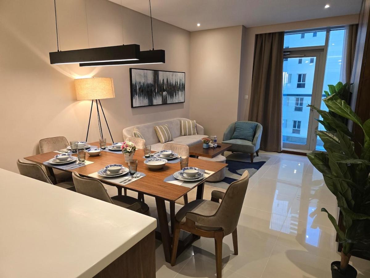 a living room with a wooden table and chairs at Sea view 3 bd room apartment in Manama