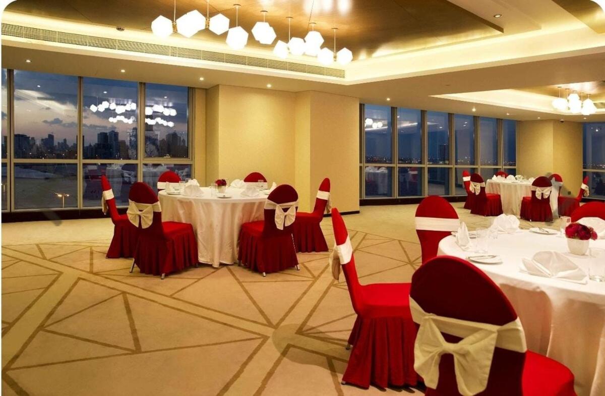 a banquet hall with white tables and red chairs at Sea view 3 bd room apartment in Manama +27 photos