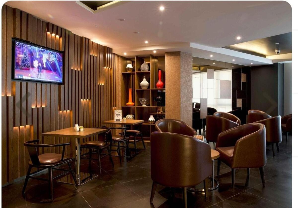 a restaurant with tables and chairs and a tv on the wall at Sea view 3 bd room apartment in Manama