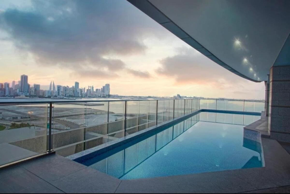 a swimming pool on top of a building with a city skyline at Sea view 3 bd room apartment in Manama