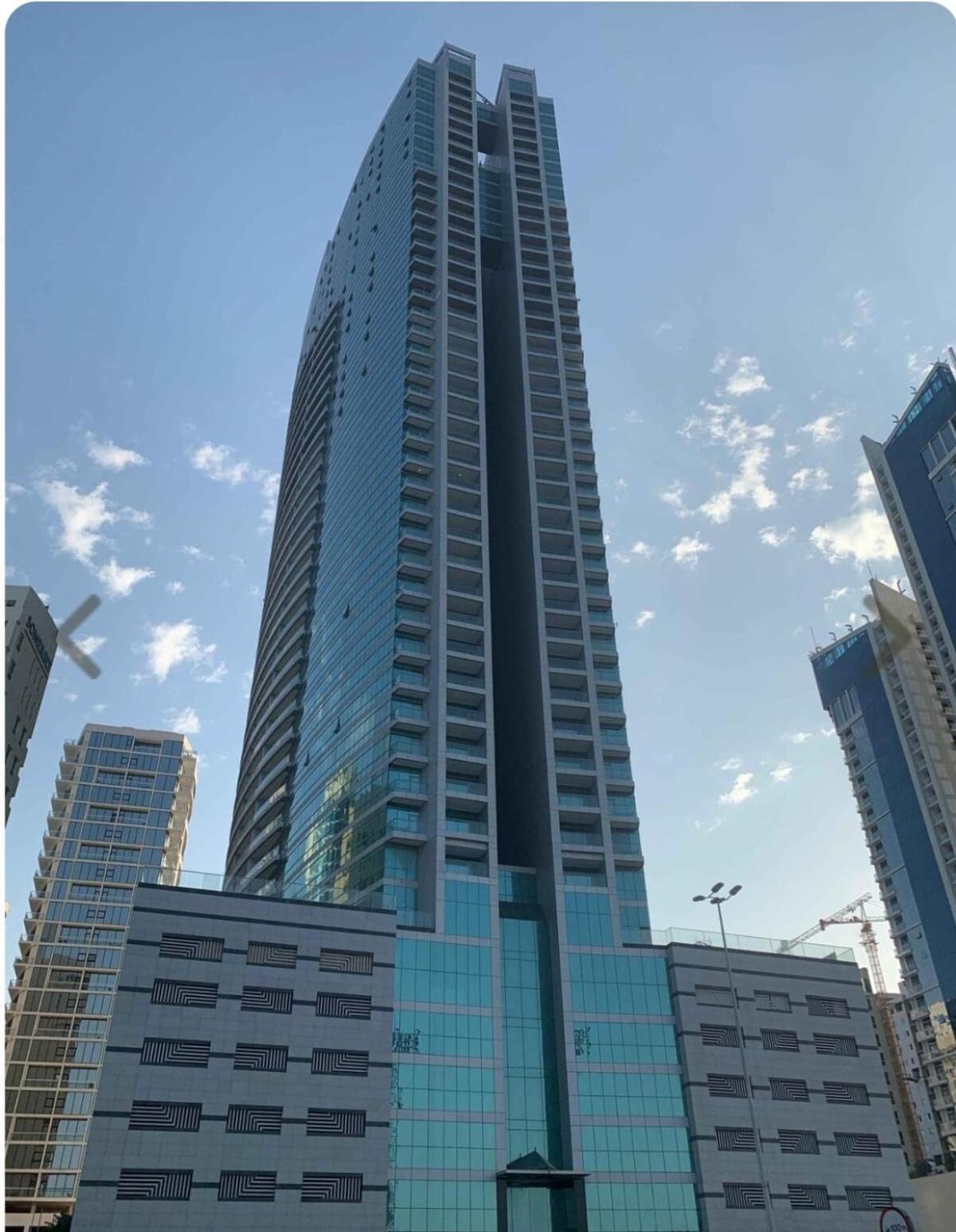 a tall glass building in front of some buildings at Sea view 3 bd room apartment in Manama