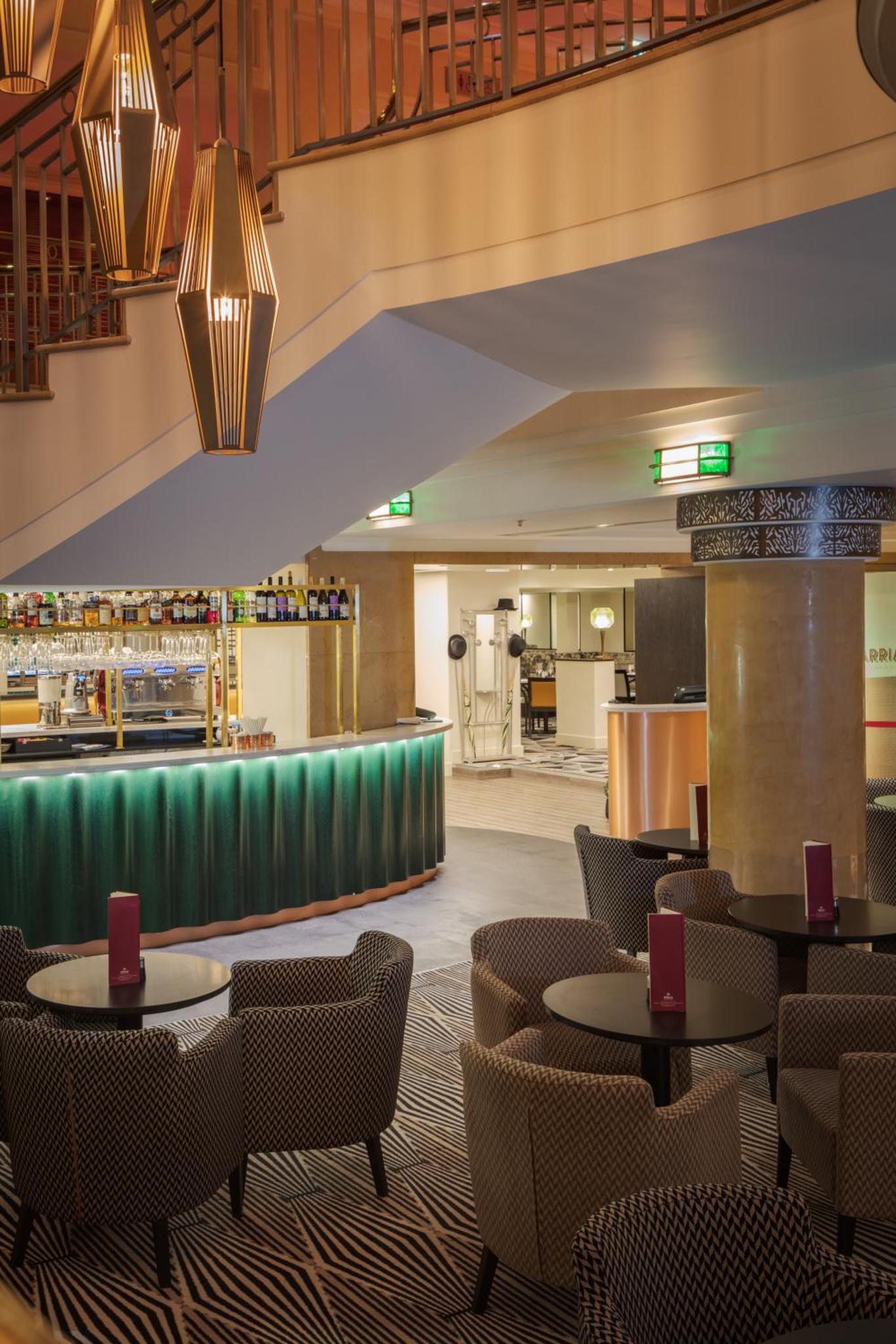 a restaurant with tables and chairs and a bar at Hilton London Paddington in London