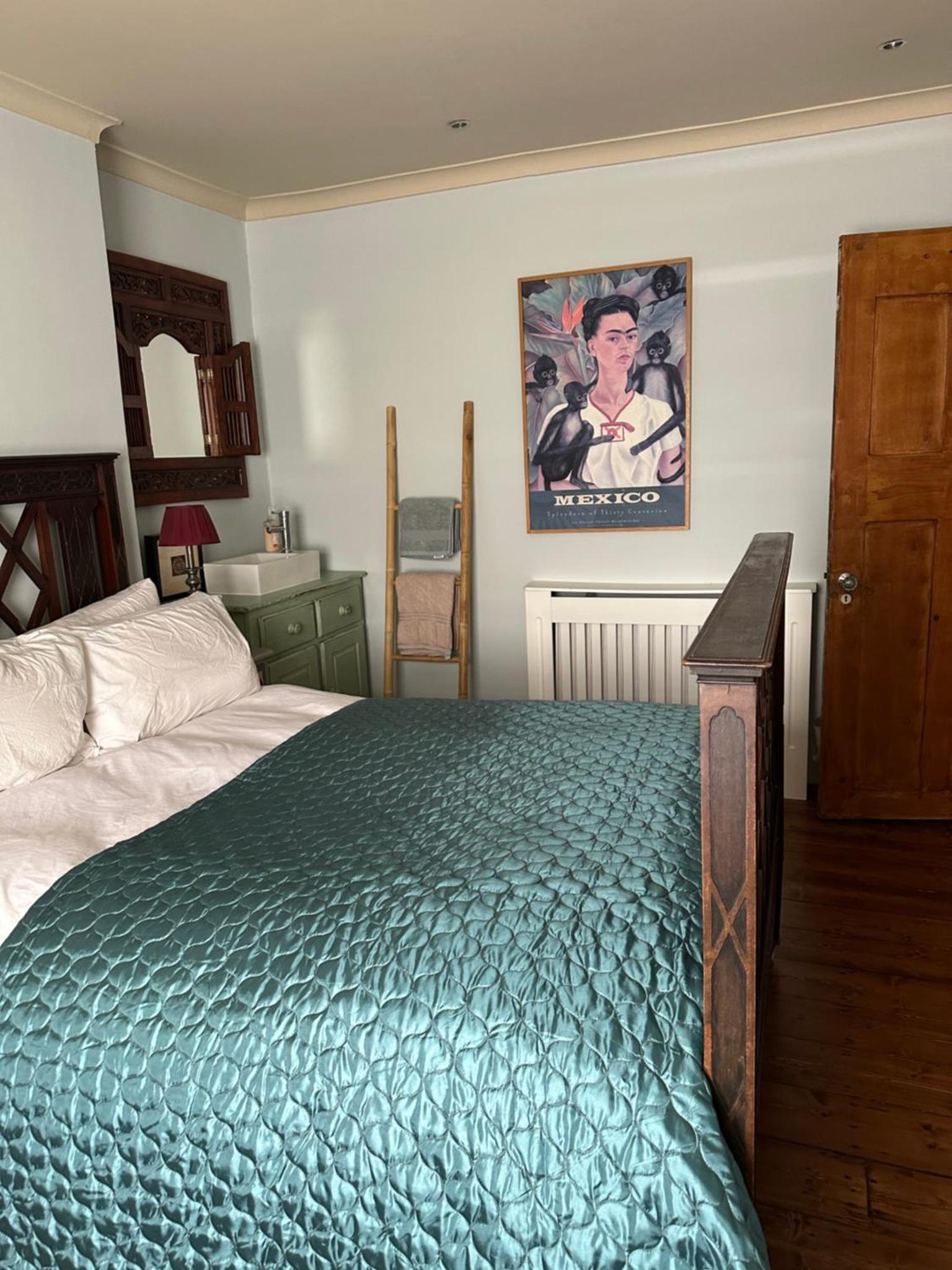 a bedroom with a large bed with a blue blanket at Centrally Located Boutique Townhouse in London