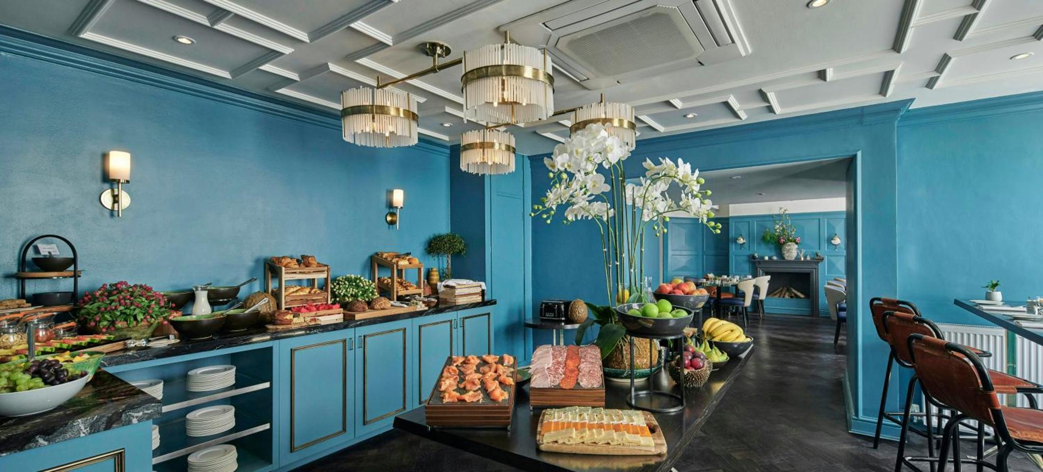 a blue room with a table with food on it at The Academy - Small Luxury Hotels of the World in London +11 photos