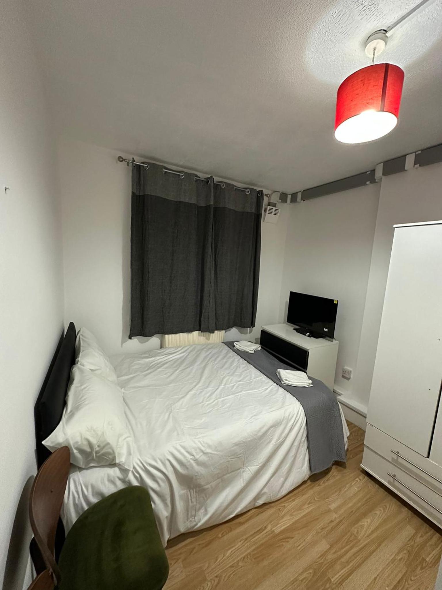 a bedroom with a bed and a desk and a window at Budget Ensuit Room, Quiet Stay, East London, Fast WiFi, Steps Away From London Eye, Near Metro in London