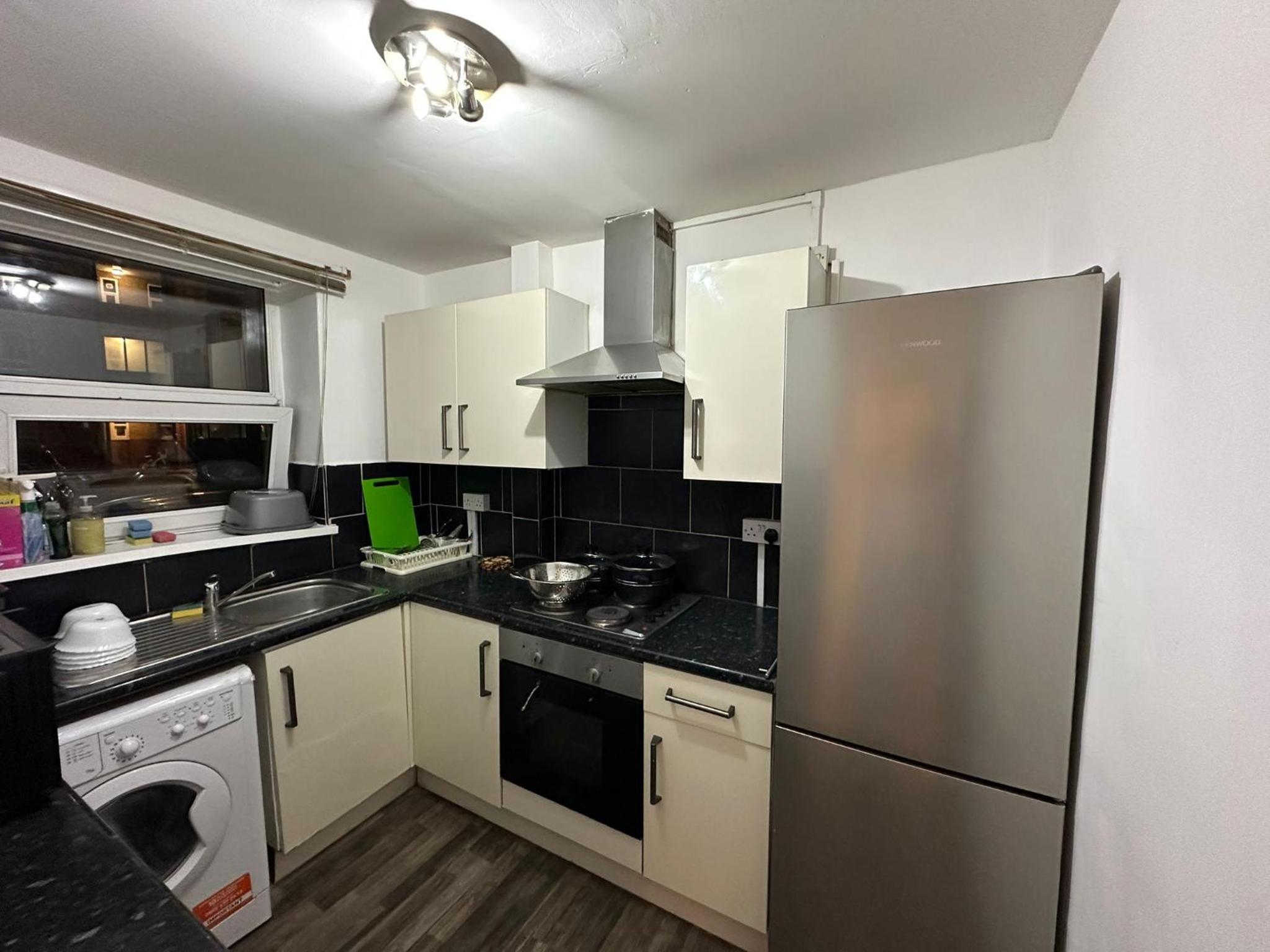 a kitchen with a stainless steel refrigerator and a dishwasher at Budget Ensuit Room, Quiet Stay, East London, Fast WiFi, Steps Away From London Eye, Near Metro in London