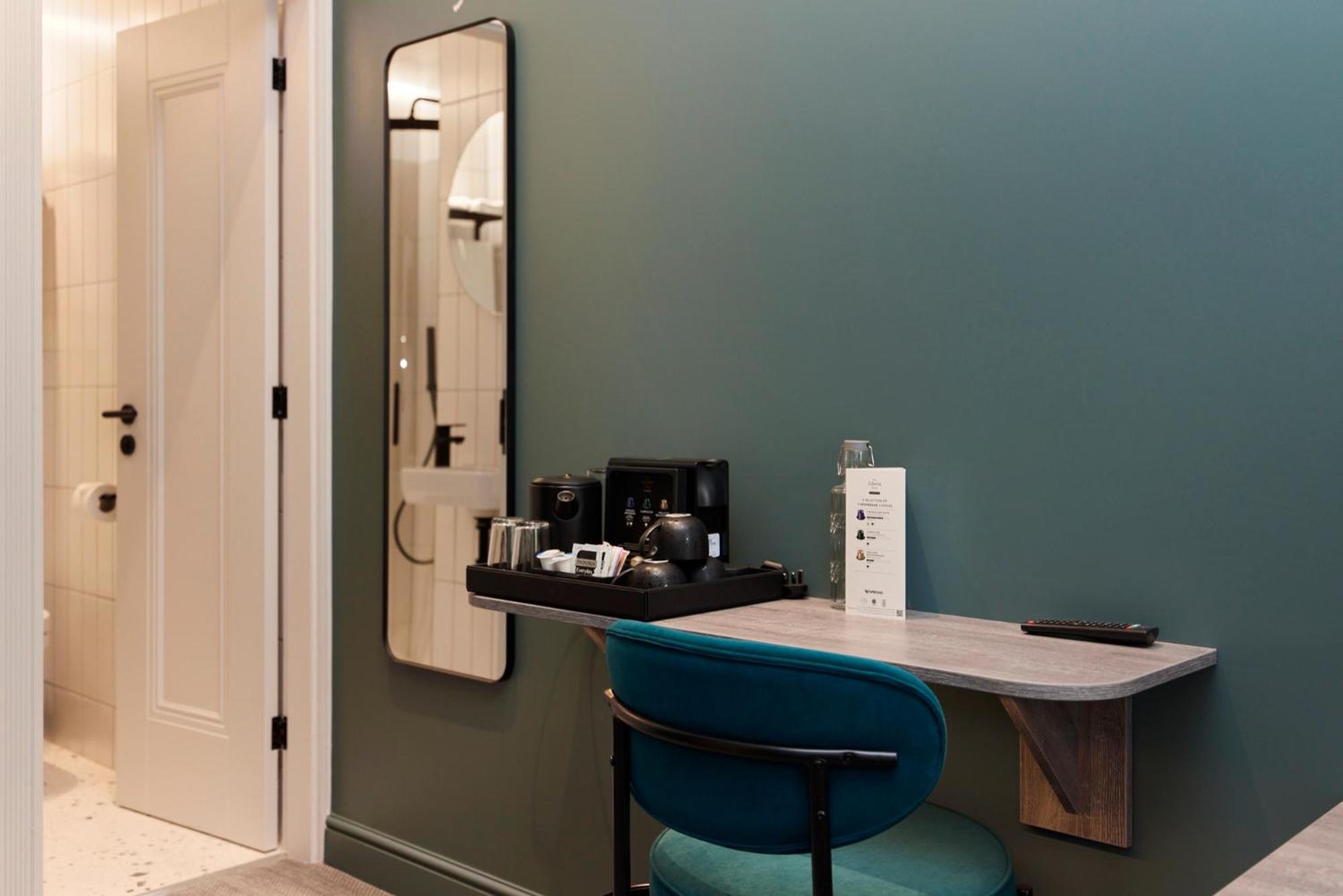 a blue chair sitting at a counter in a room at The Edwin Hotel in London +76 photos