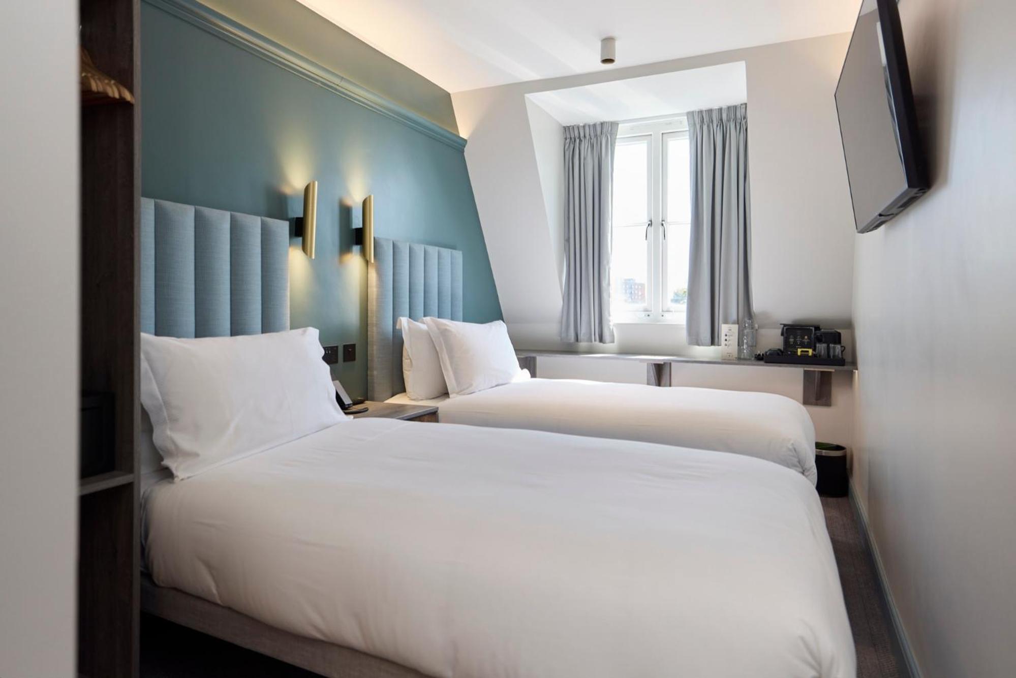 a hotel room with two beds and a television at The Edwin Hotel in London