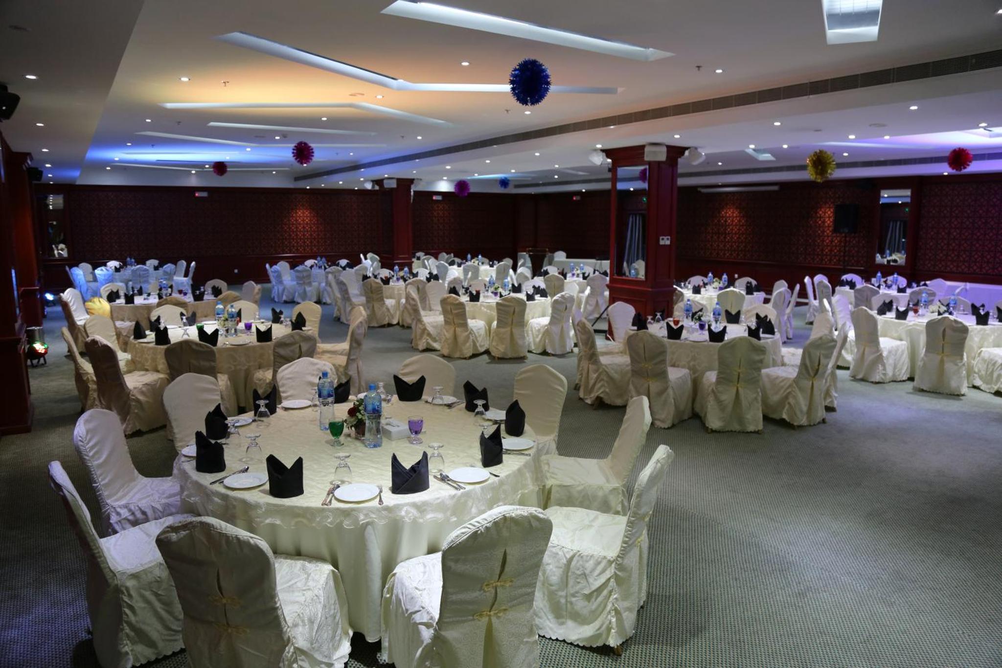a large banquet hall with white tables and chairs at The Olive Hotel, Juffair in Manama +61 photos