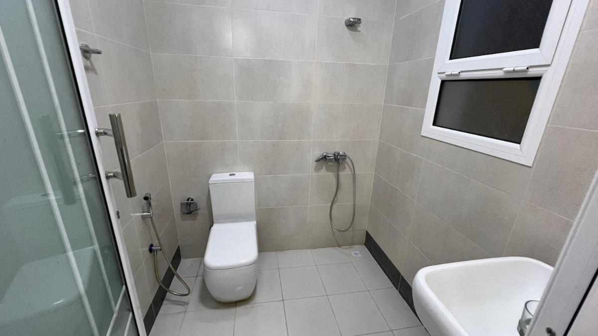 a bathroom with a toilet and a sink and a shower at Beachside villa with a pool! in Karzakkān