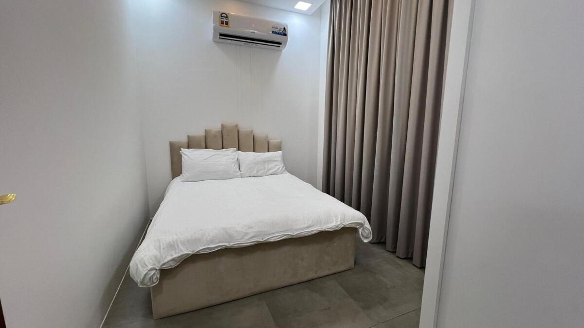 a bed with white sheets and pillows in a room at Beachside villa with a pool! in Karzakkān