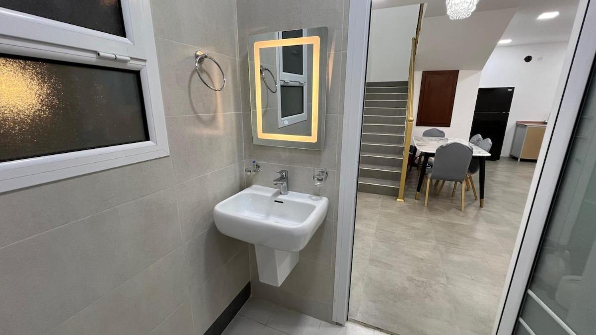 a bathroom with a sink and a mirror and a table at Beachside villa with a pool! in Karzakkān