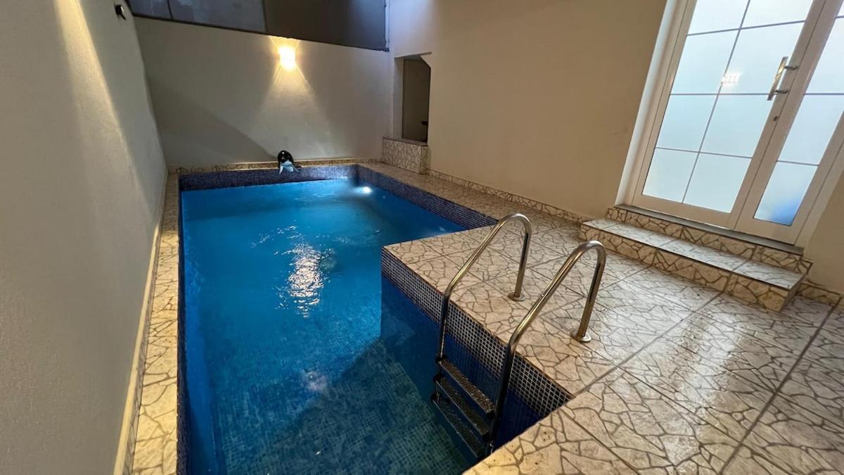 a swimming pool in a bathroom with blue water at Beachside villa with a pool! in Karzakkān +1 photo