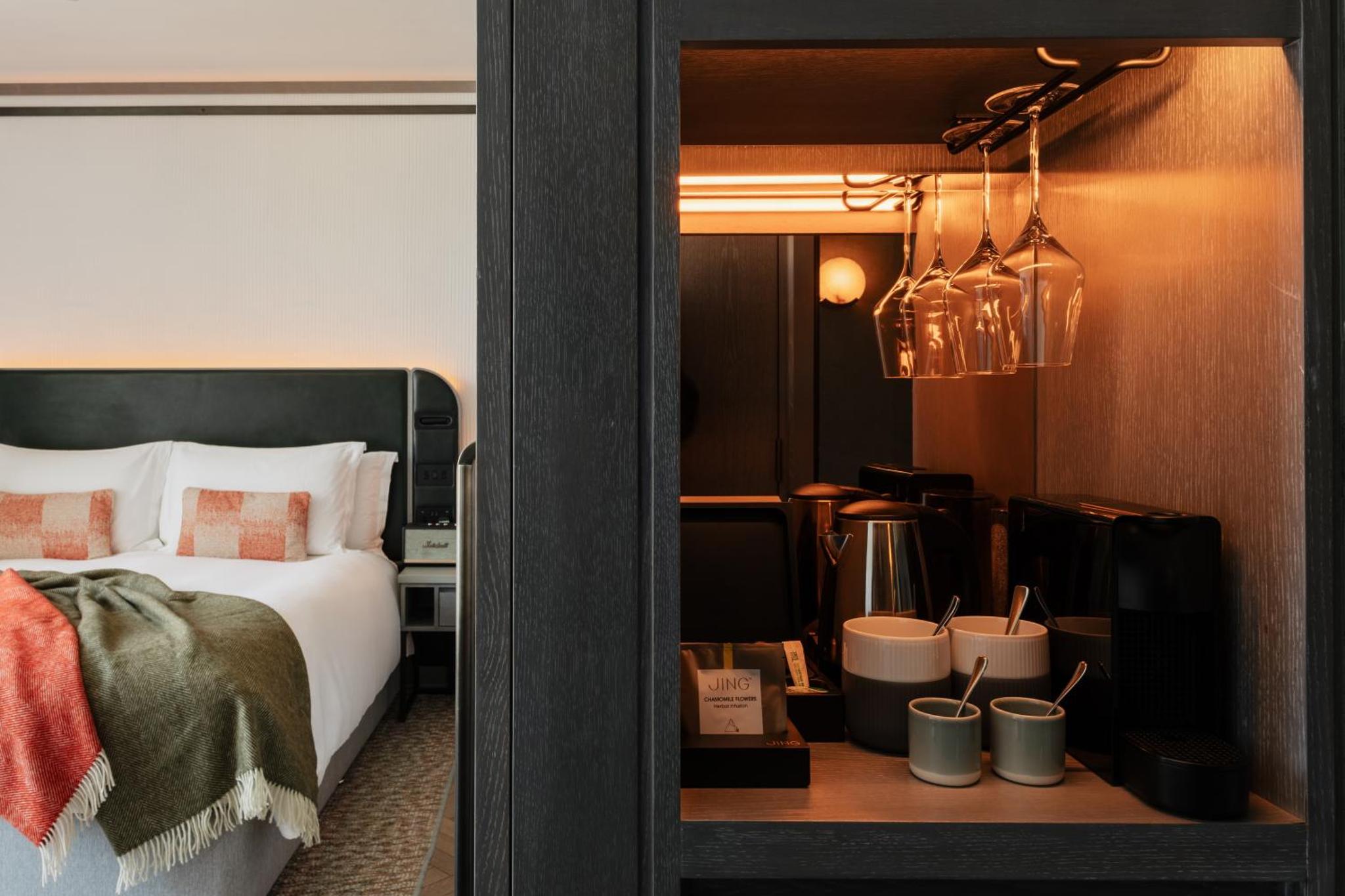 a hotel room with a bed and a table with a bed at Hart Shoreditch Hotel London, Curio Collection by Hilton in London