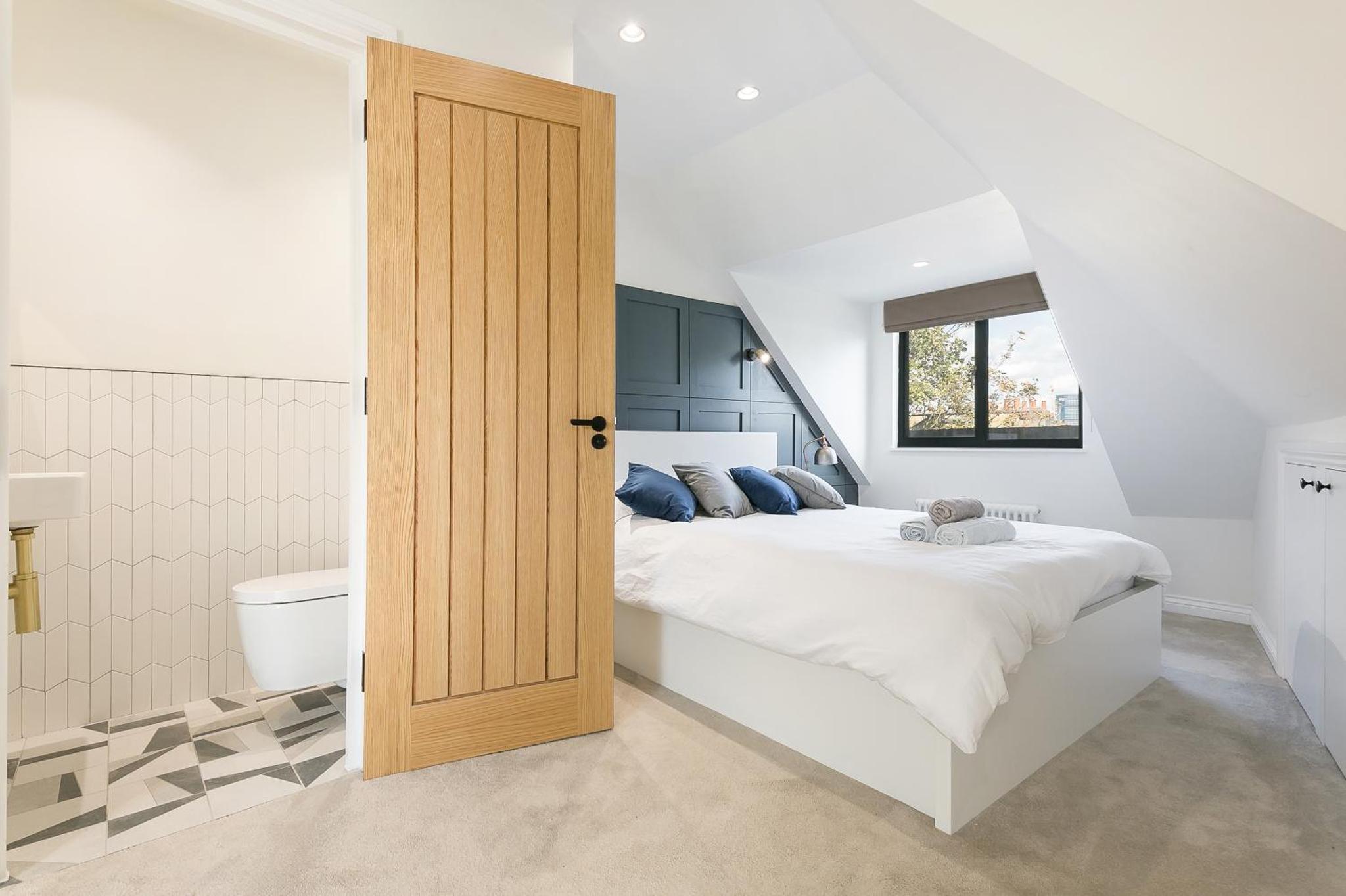 a white bedroom with a bed and a toilet at Luxe 2 bed - 20 minutes from Central London in London