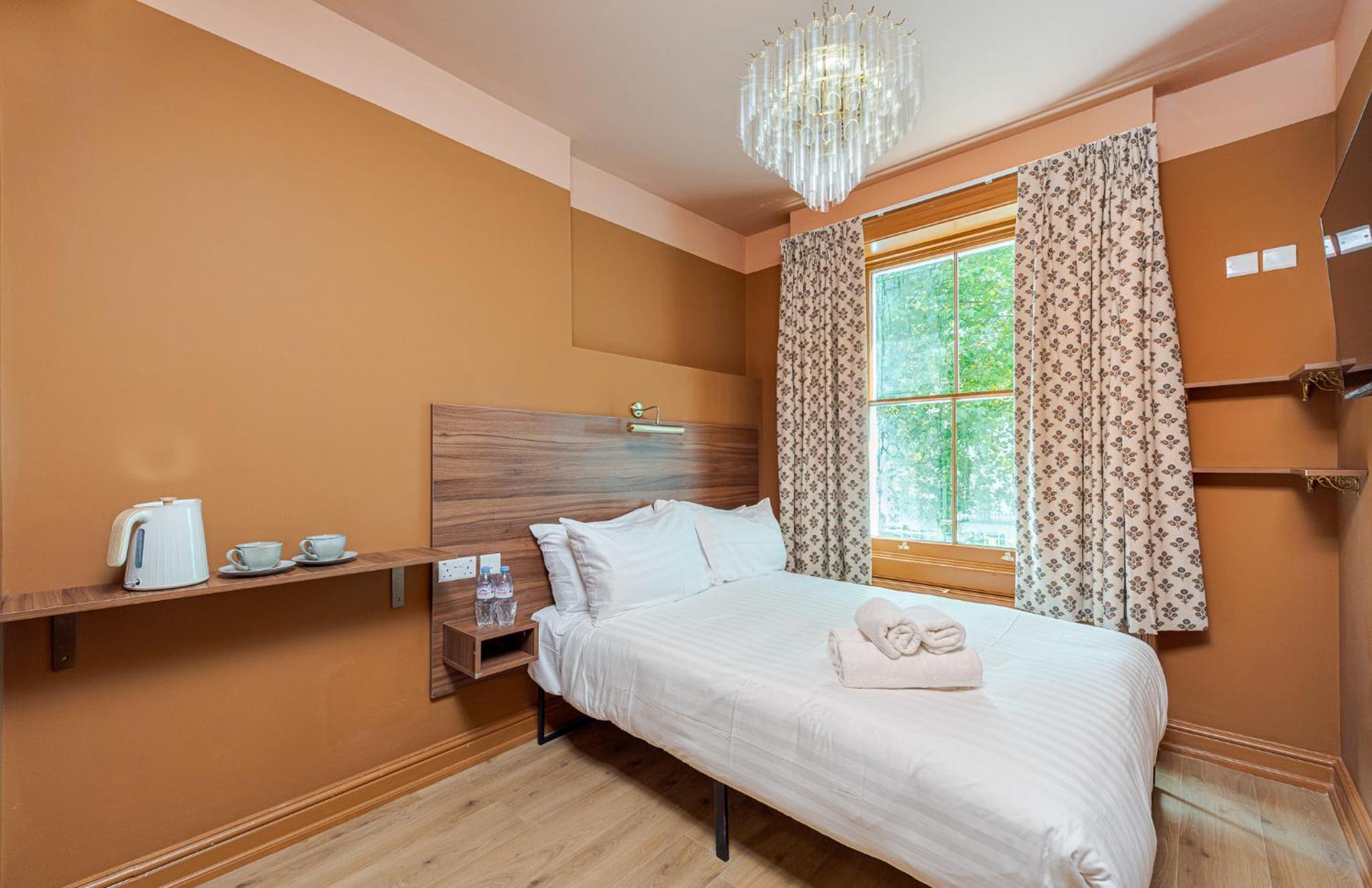 a bedroom with a bed and a window at The Norfolk, Paddington in London +21 photos