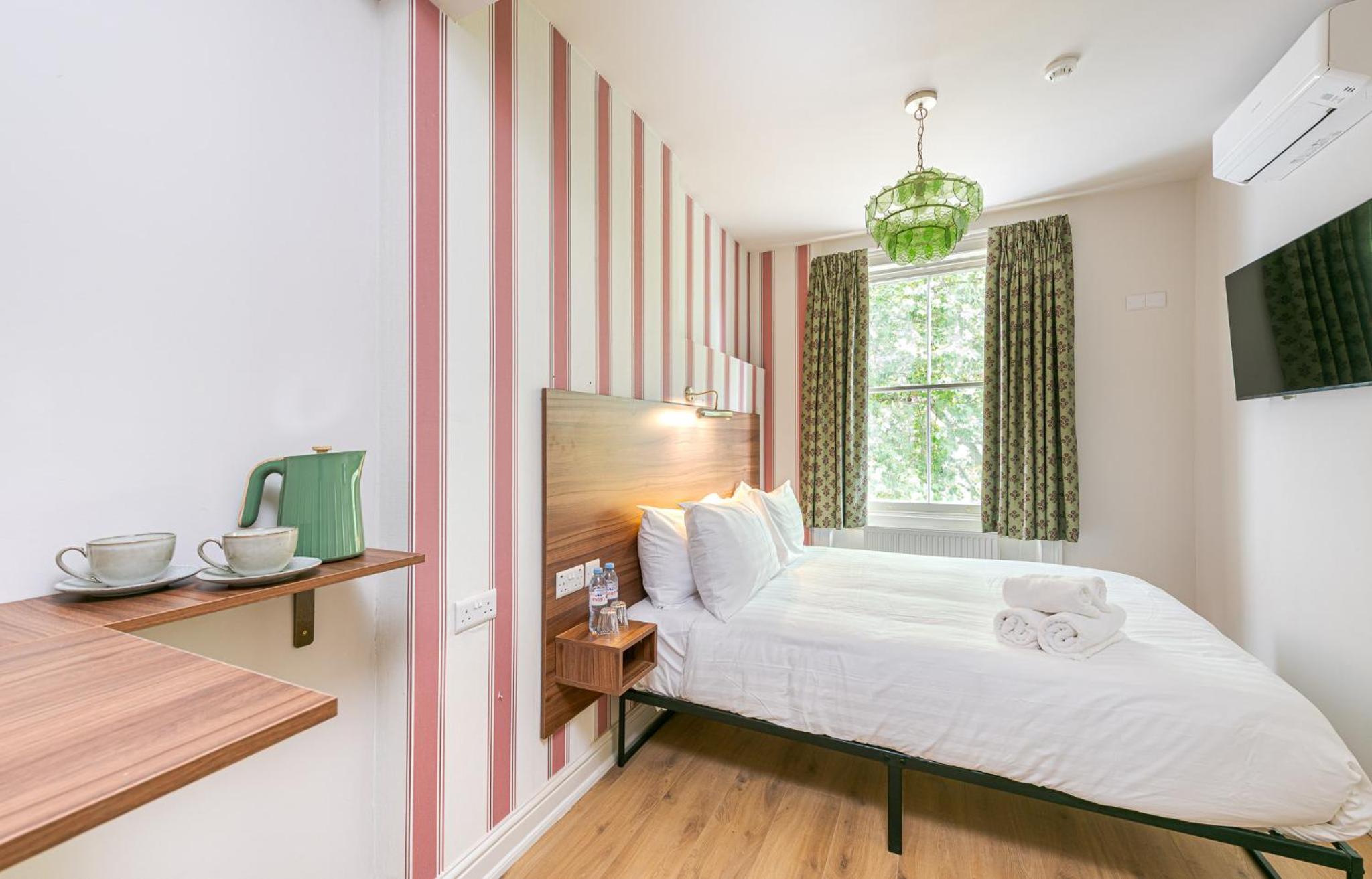 a small bedroom with a bed and a window at The Norfolk, Paddington in London