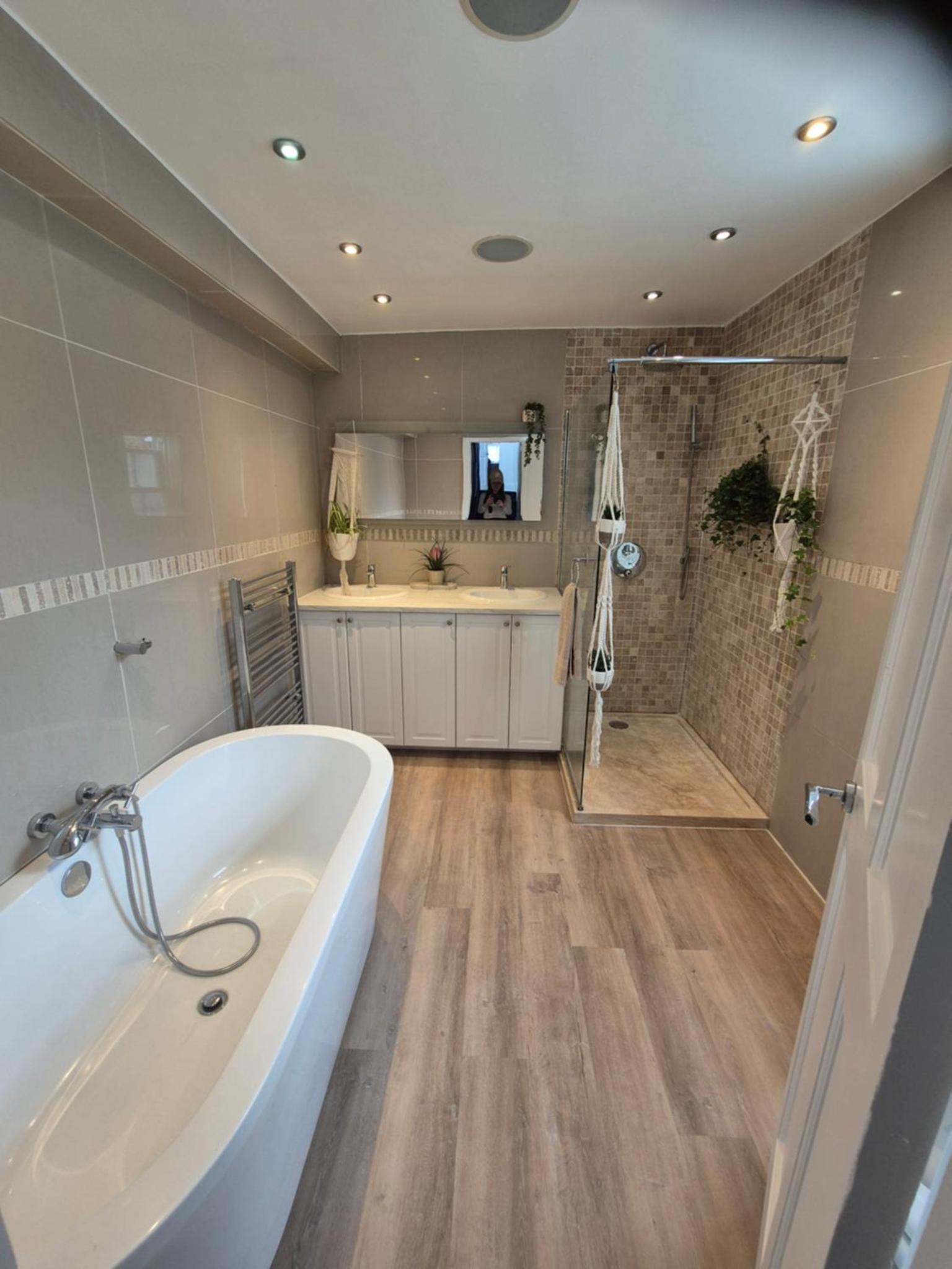a large bathroom with a tub and a shower at Bright 4 double bedroom victorian house in London