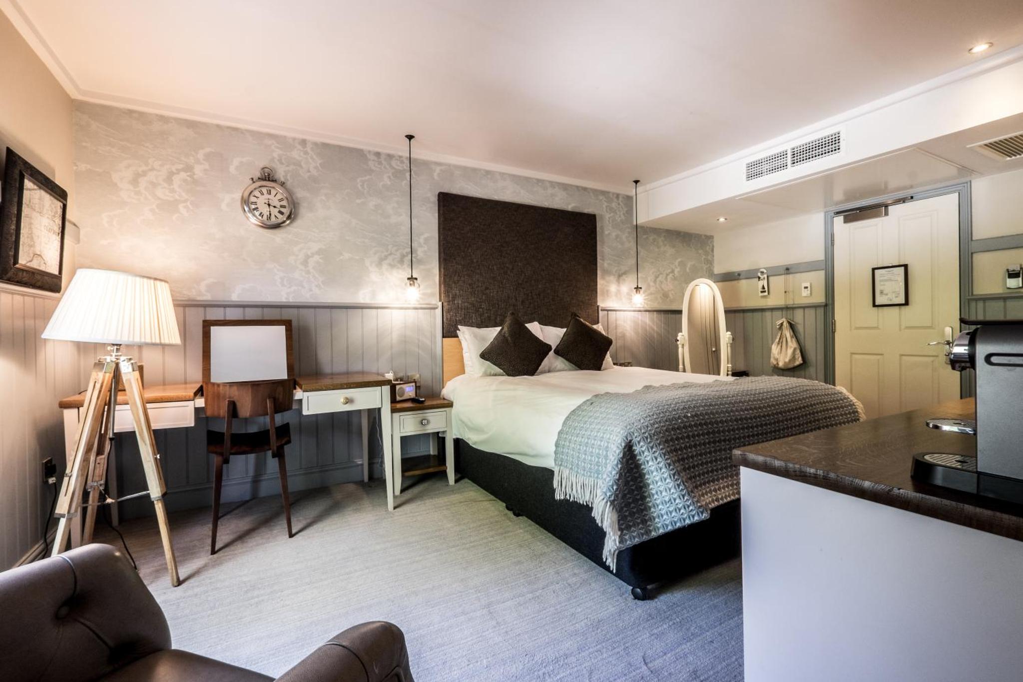 a hotel room with a bed and a desk with a desk at The Windmill On The Common in London