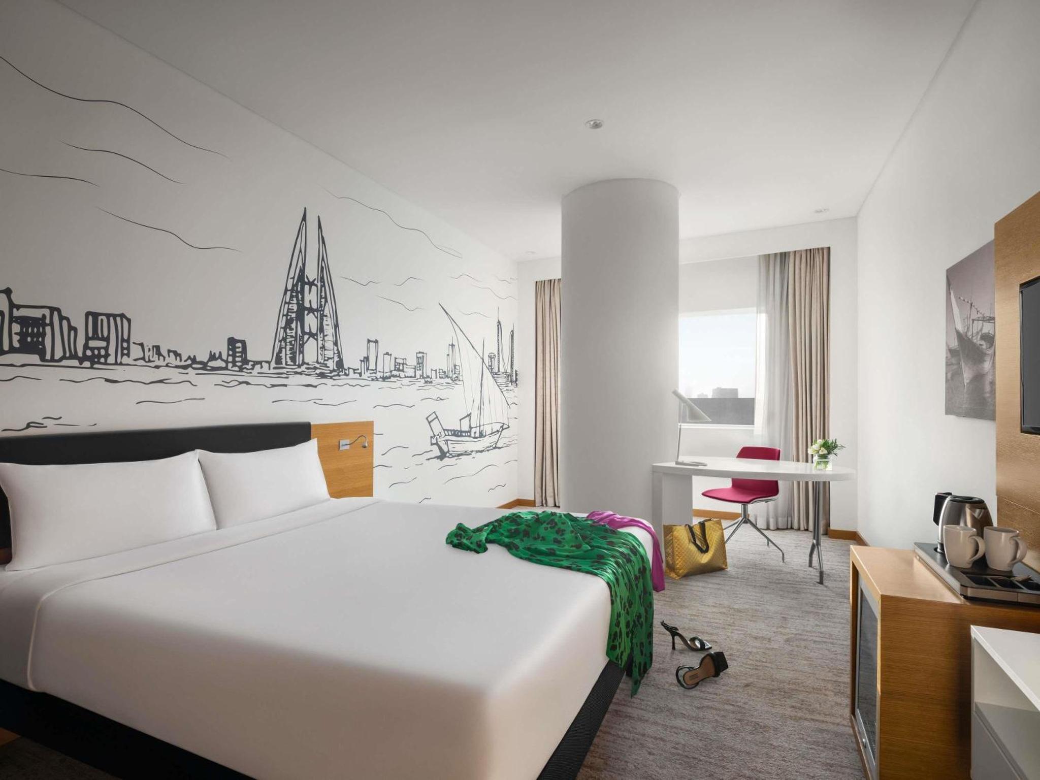 a hotel room with a bed and a desk at ibis Styles Manama Diplomatic Area in Manama +110 photos