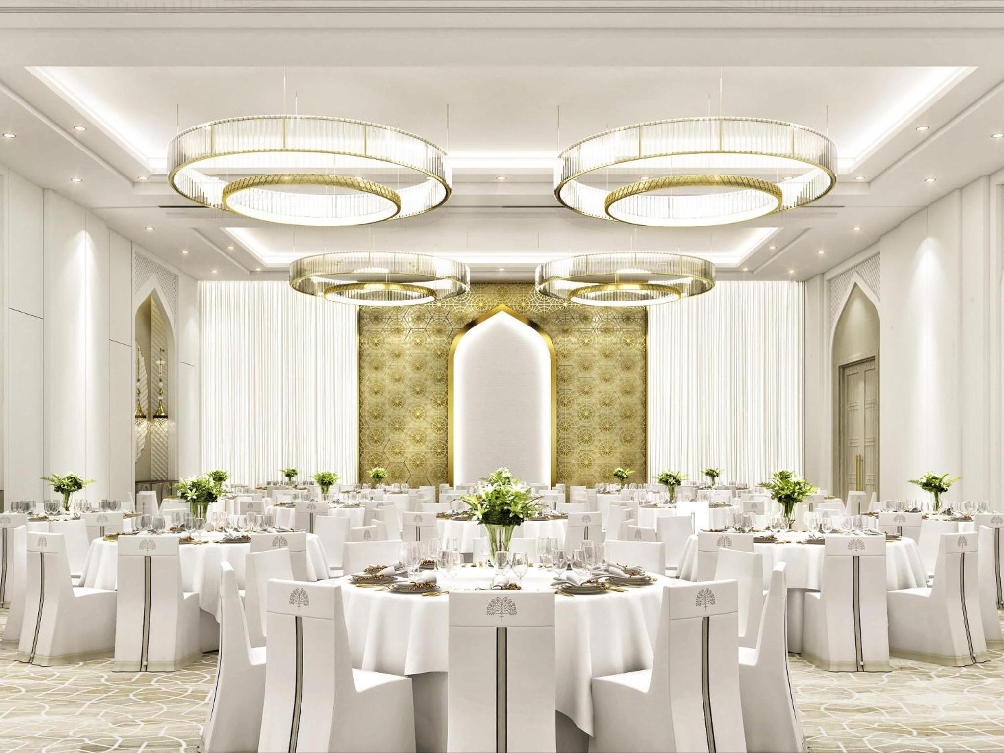 a banquet hall with white tables and chairs and chandeliers at Raffles Al Areen Palace Bahrain in Manama +146 photos