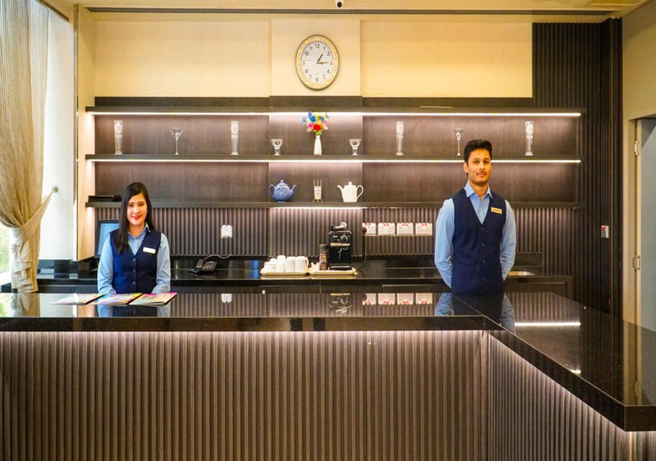 a man and a woman standing at a counter at Manama Tower Hotel in Manama