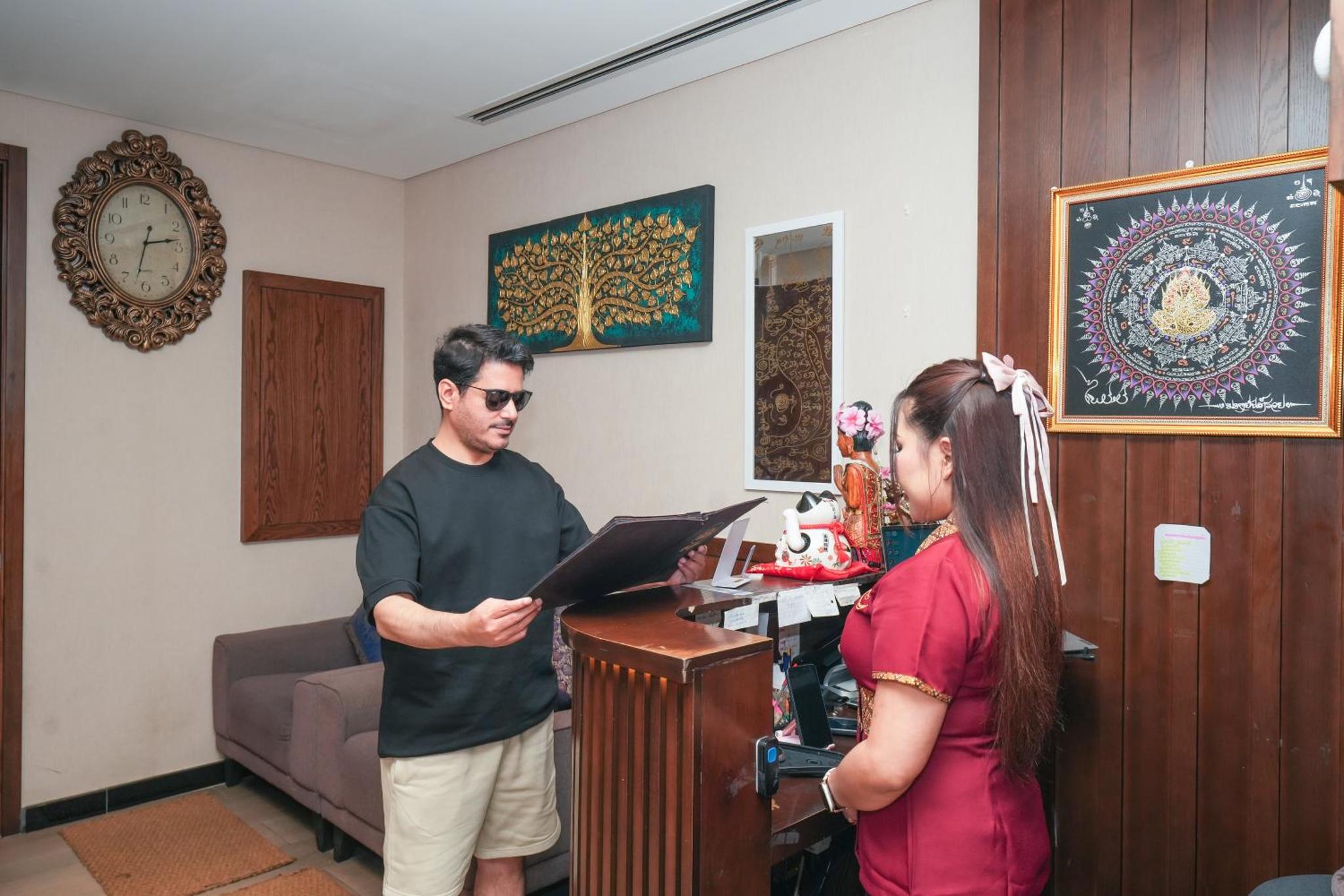 a man and a woman standing in a room with a laptop at Eden Garden Hotel Apartment in Manama +34 photos