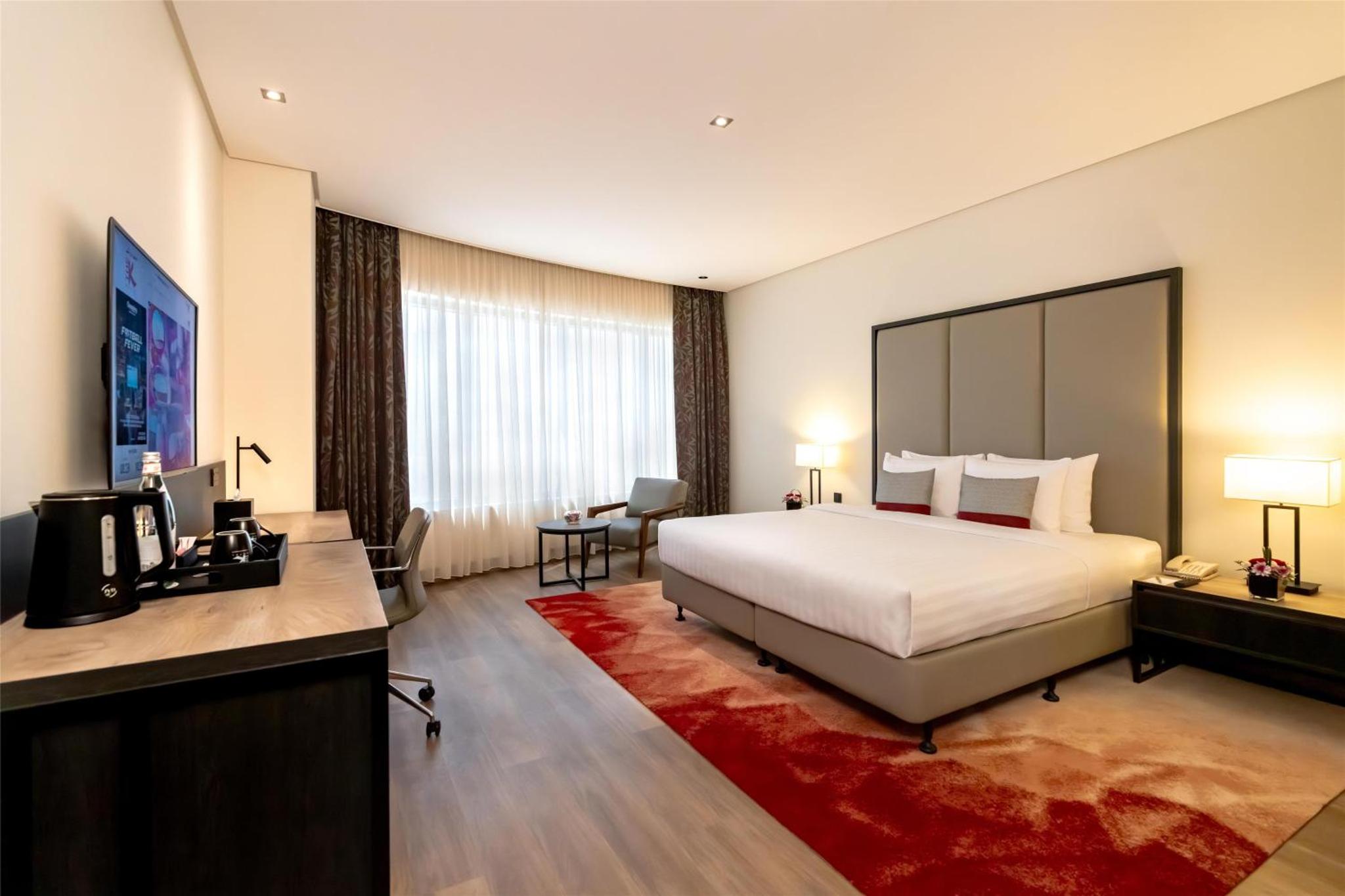 a hotel room with a large bed and a desk at The K Hotel in Manama