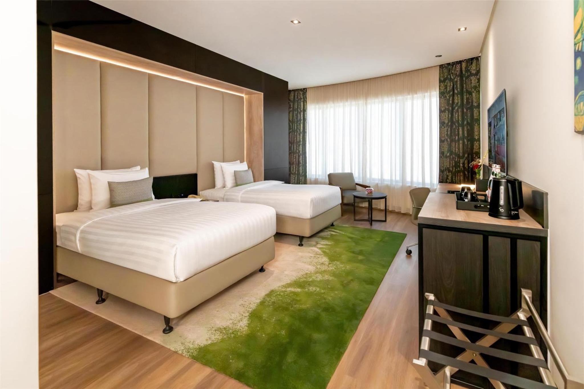 a hotel room with two beds and a desk at The K Hotel in Manama +147 photos