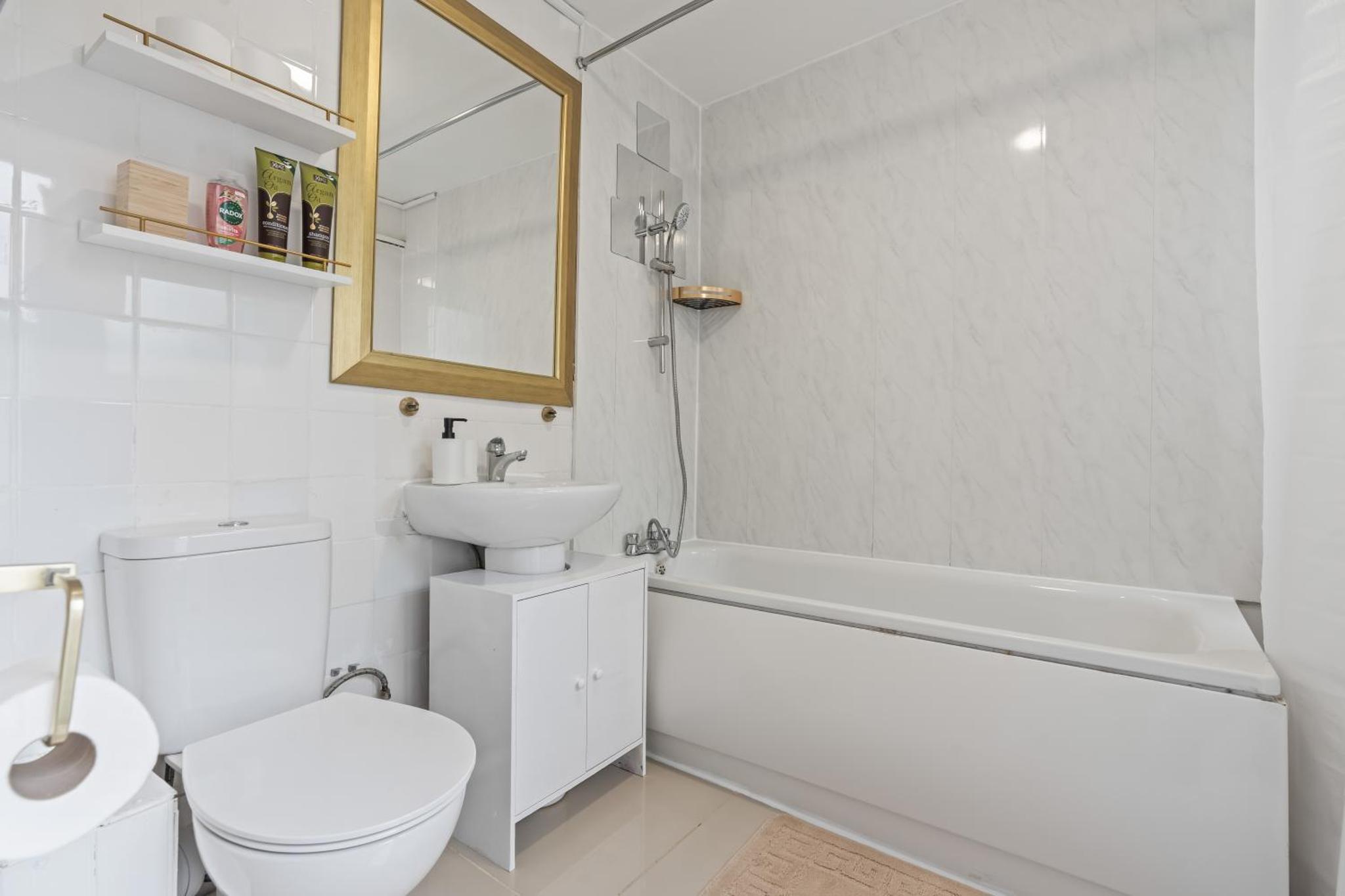 a bathroom with a toilet and a sink and a bath tub at Stylish 3 Bed Fulham Sleeps 10, Stamford Bridge in London +17 photos