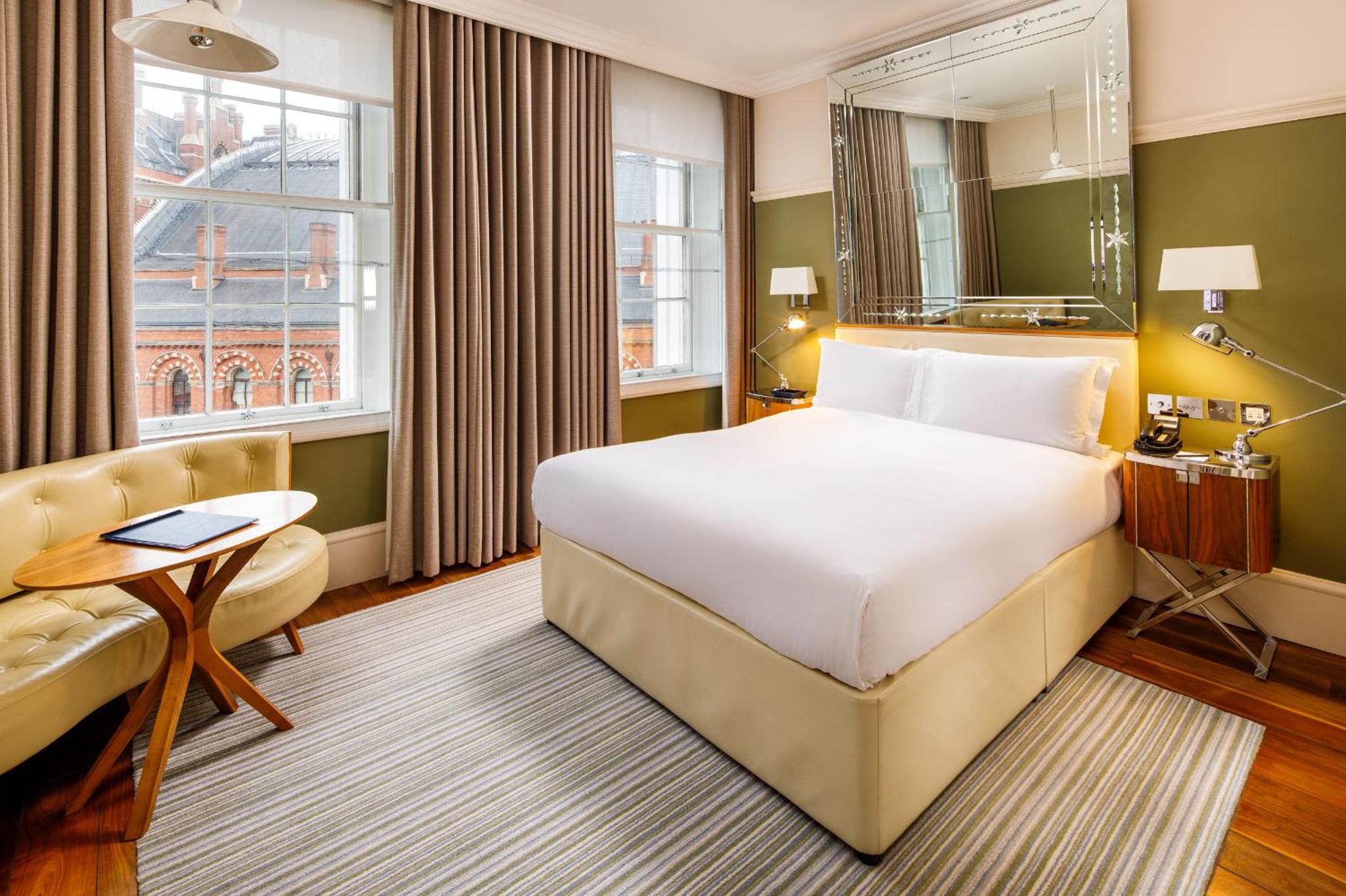 a hotel room with a bed and a couch at Kaya Great Northern Hotel, London in London