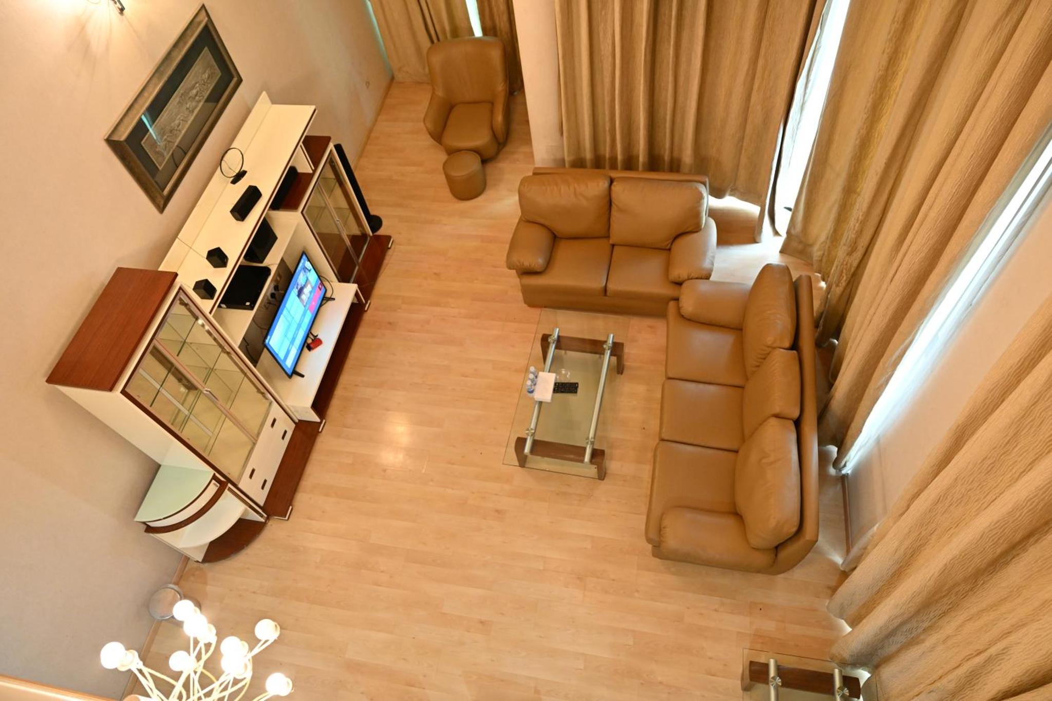 an overhead view of a living room with chairs and a television at One Pavilion Luxury Serviced Apartments in Manama