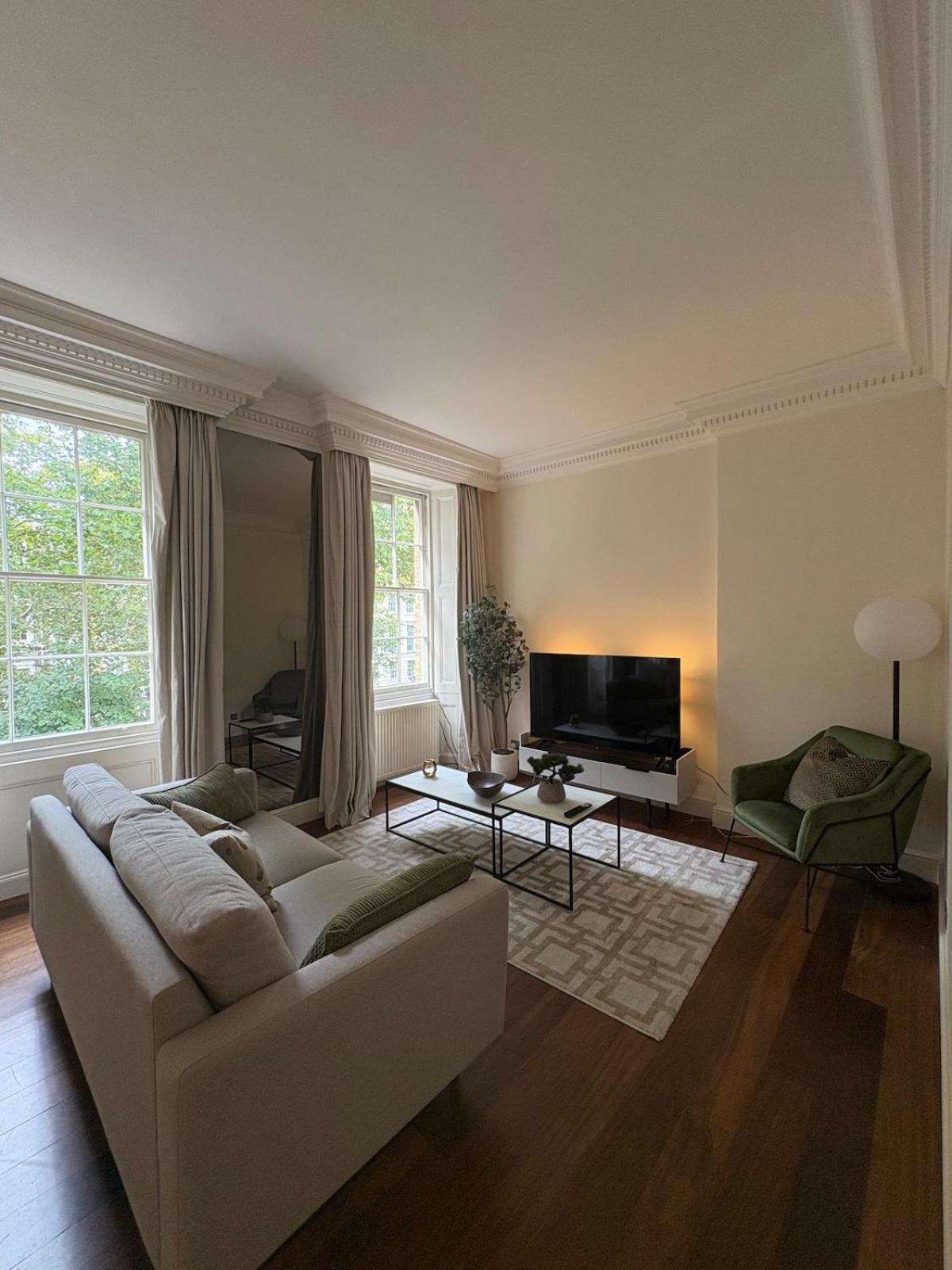 a living room with a white couch and a television at Stylish 1 Bed in Knightsbridge Prime Location in London