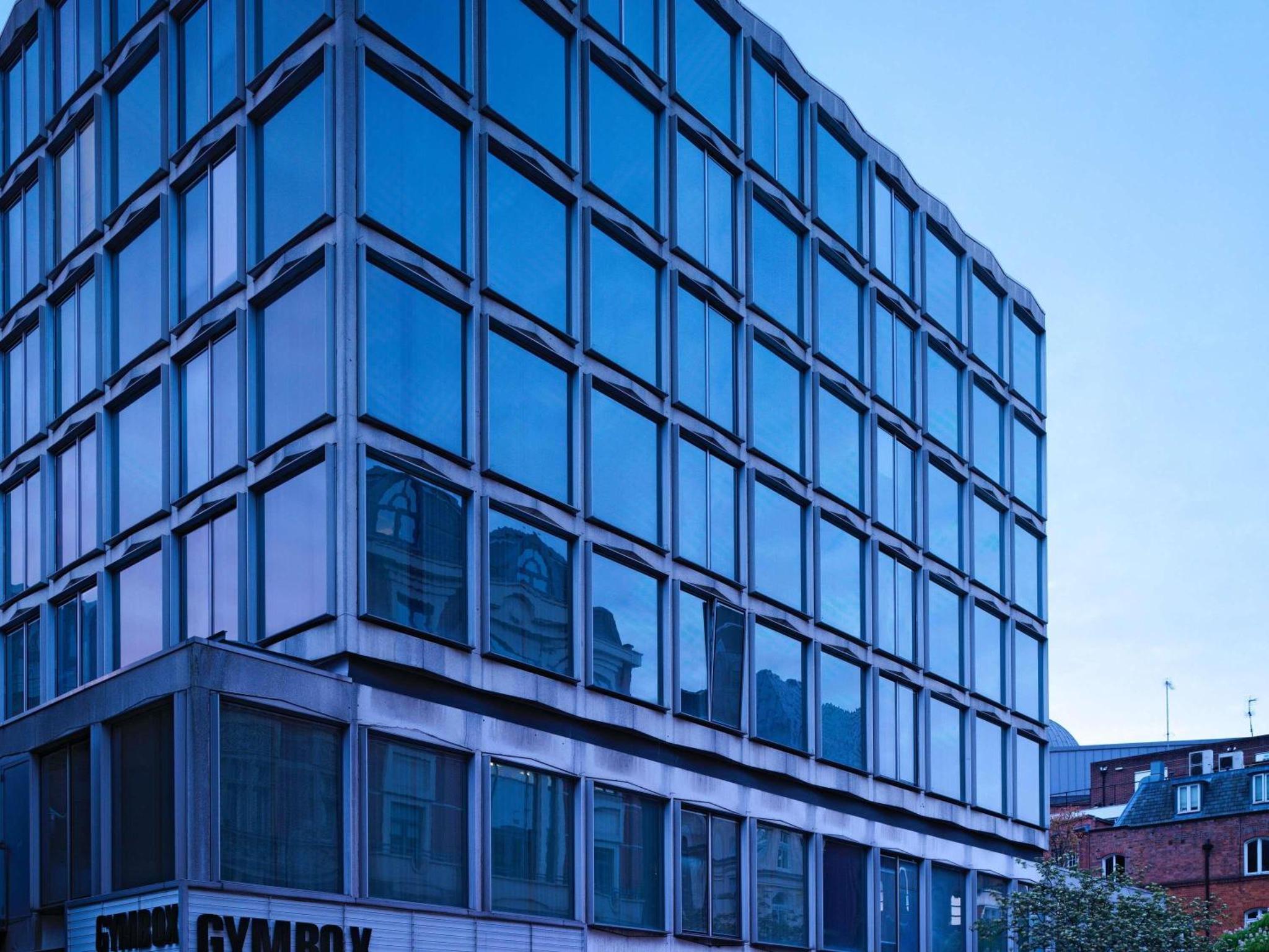 an office building with blue glass windows at St Martins Lane London in London