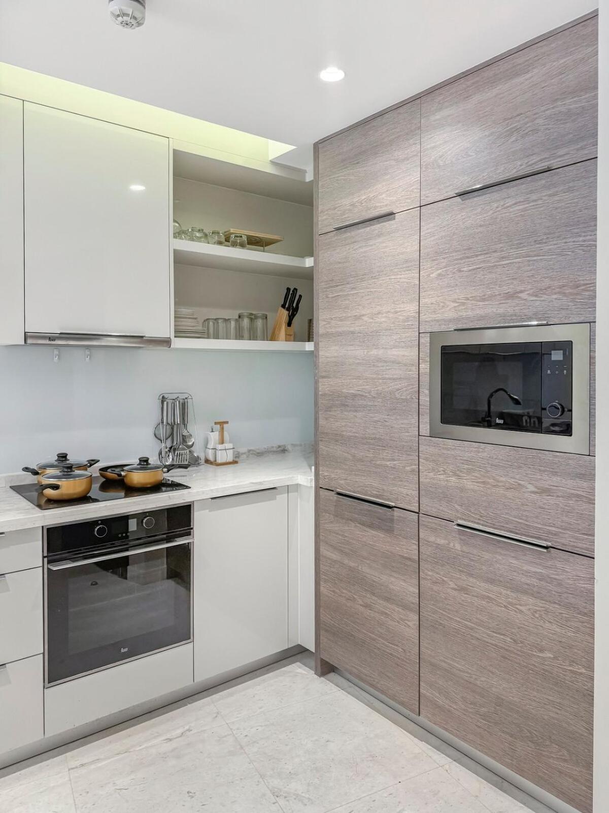 a kitchen with stainless steel appliances and wooden cabinets at 2BR Four Season View in Water Bay in Manama